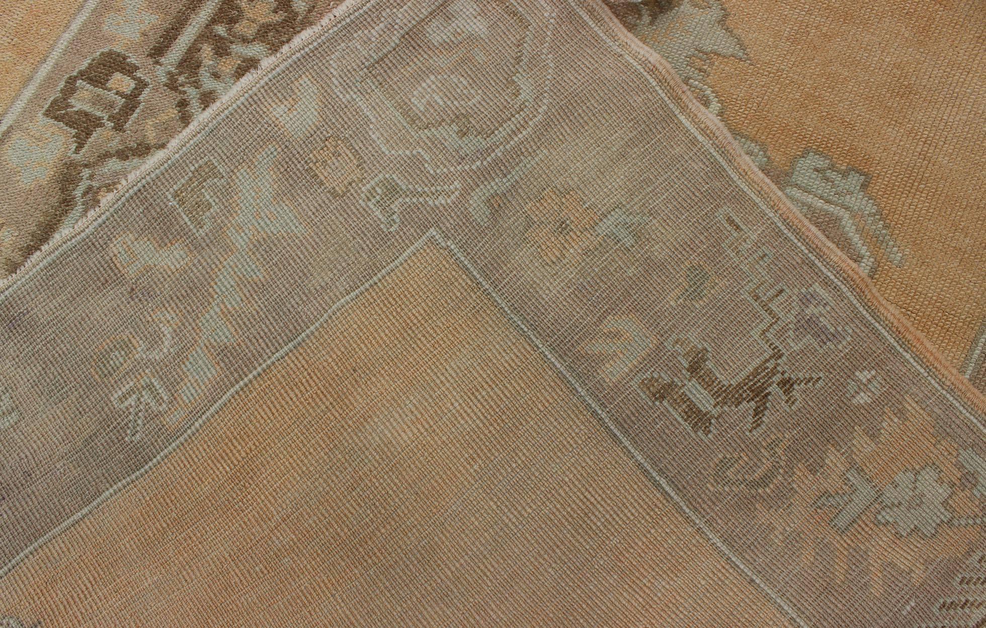 Alfombra antigua Oushak con tres medallones centrales sobre un campo de color arena tenue Lana en venta
