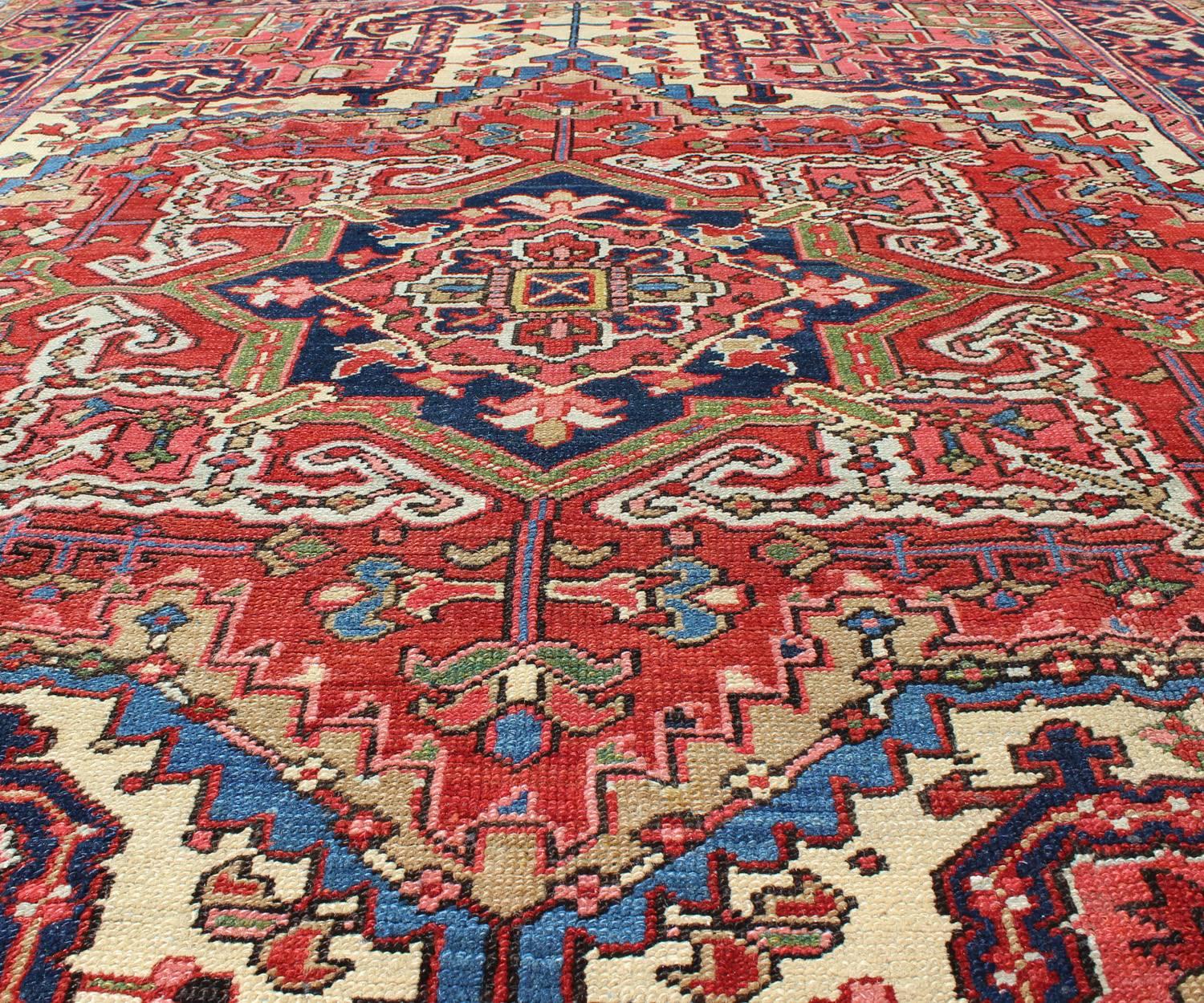 Early 20th Century Antique Persian Heriz Carpet with Stylized Central Medallion in Warm Hues of Red