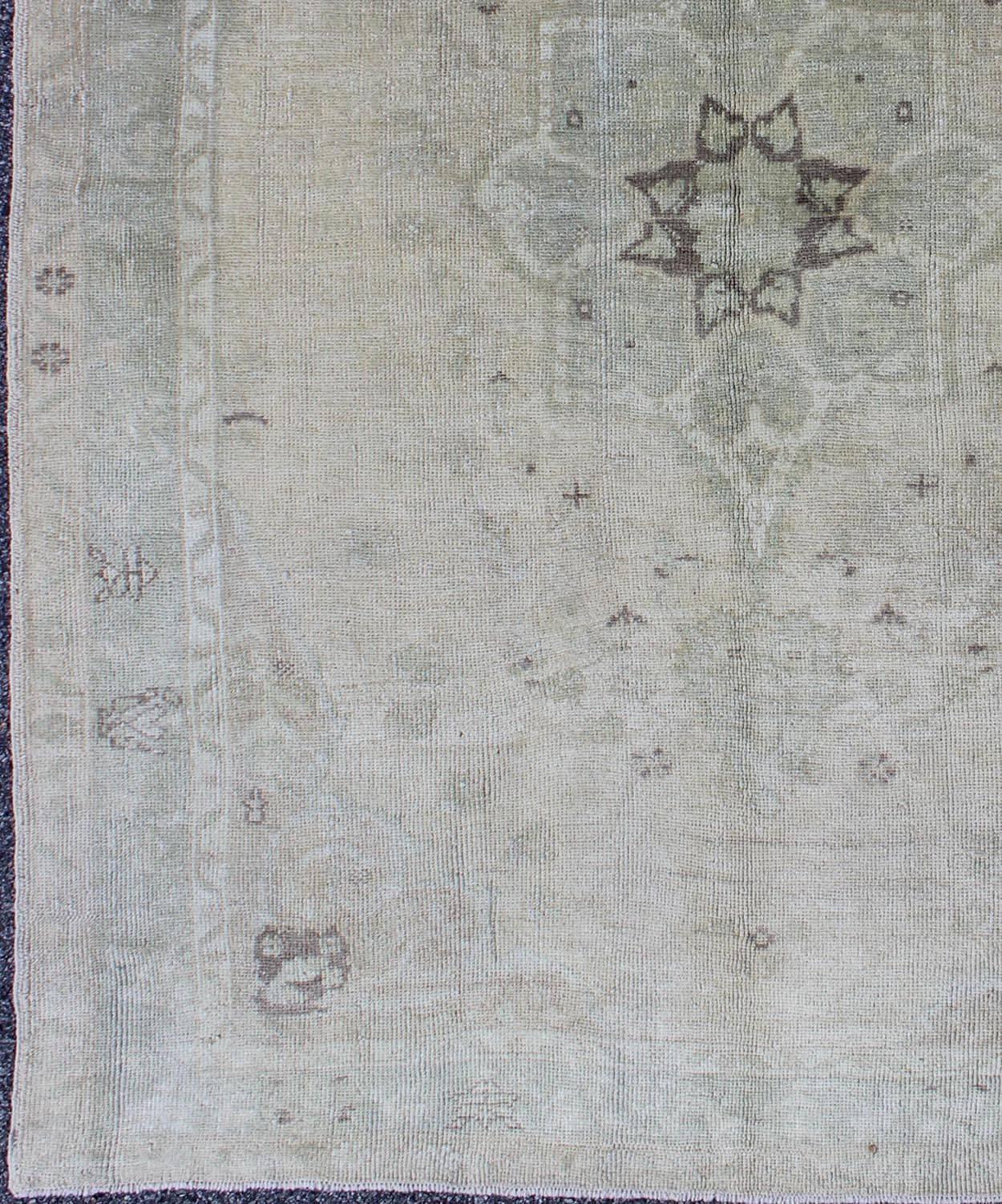 This magnificent muted Oushak from Turkey boasts a center medallion design in a large-scale style. The plentiful floral and bouquet motifs create an open design, which is surrounded by a border containing defined and botanical shapes. The colors