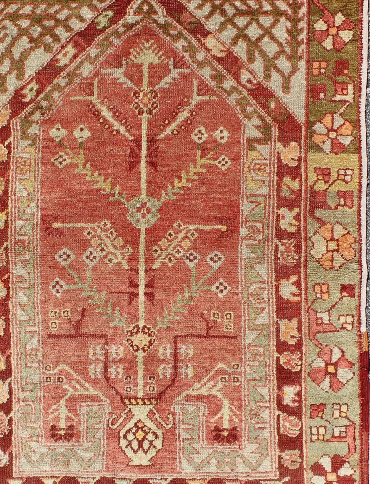 Hand-Knotted Antique Oushak Rug with Directional Tribal Motifs in Soft Pink Red & Green For Sale
