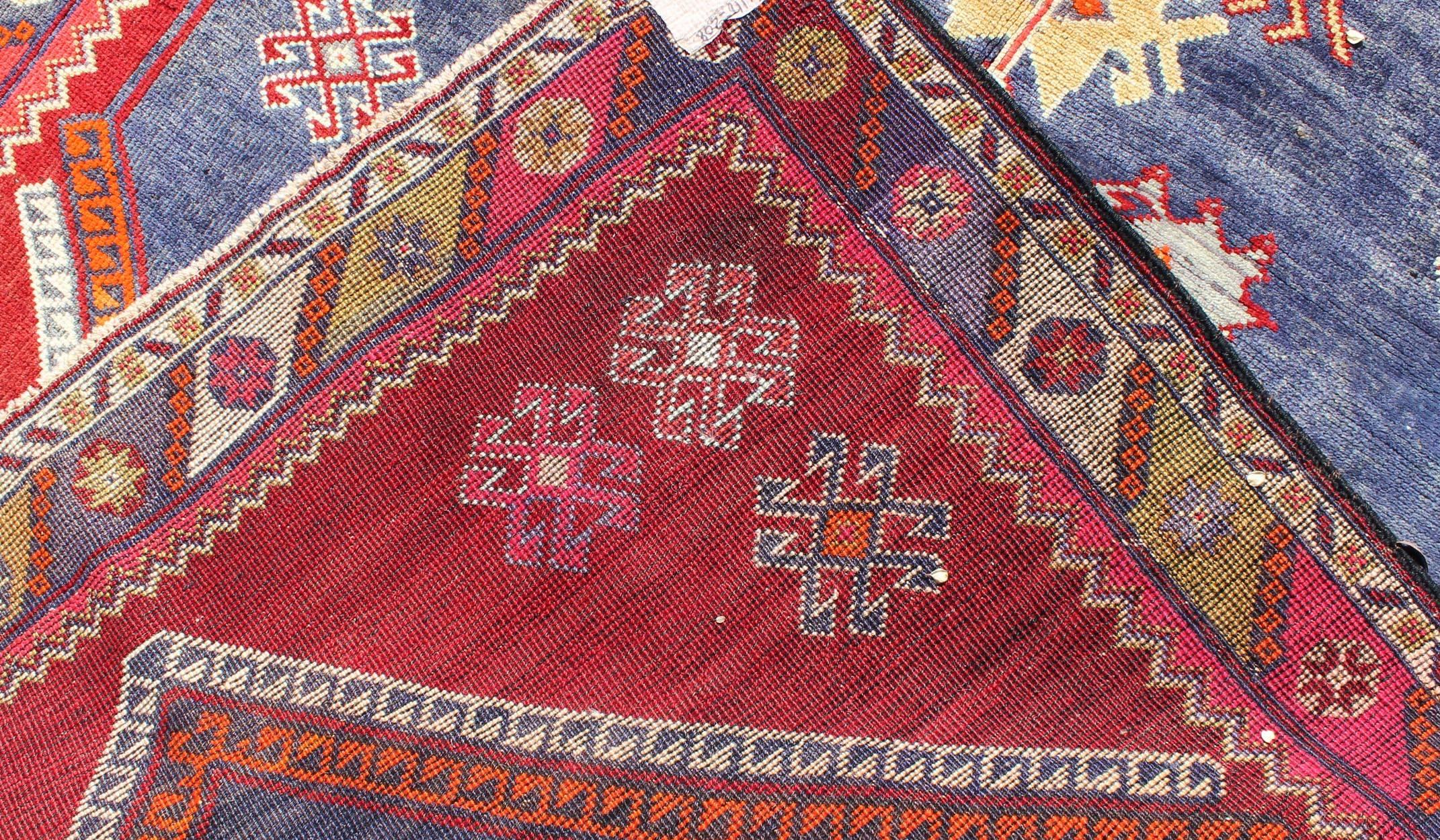 Wool Vintage Turkish Oushak Rug with Geometric Design Set on Blue and Red Background For Sale