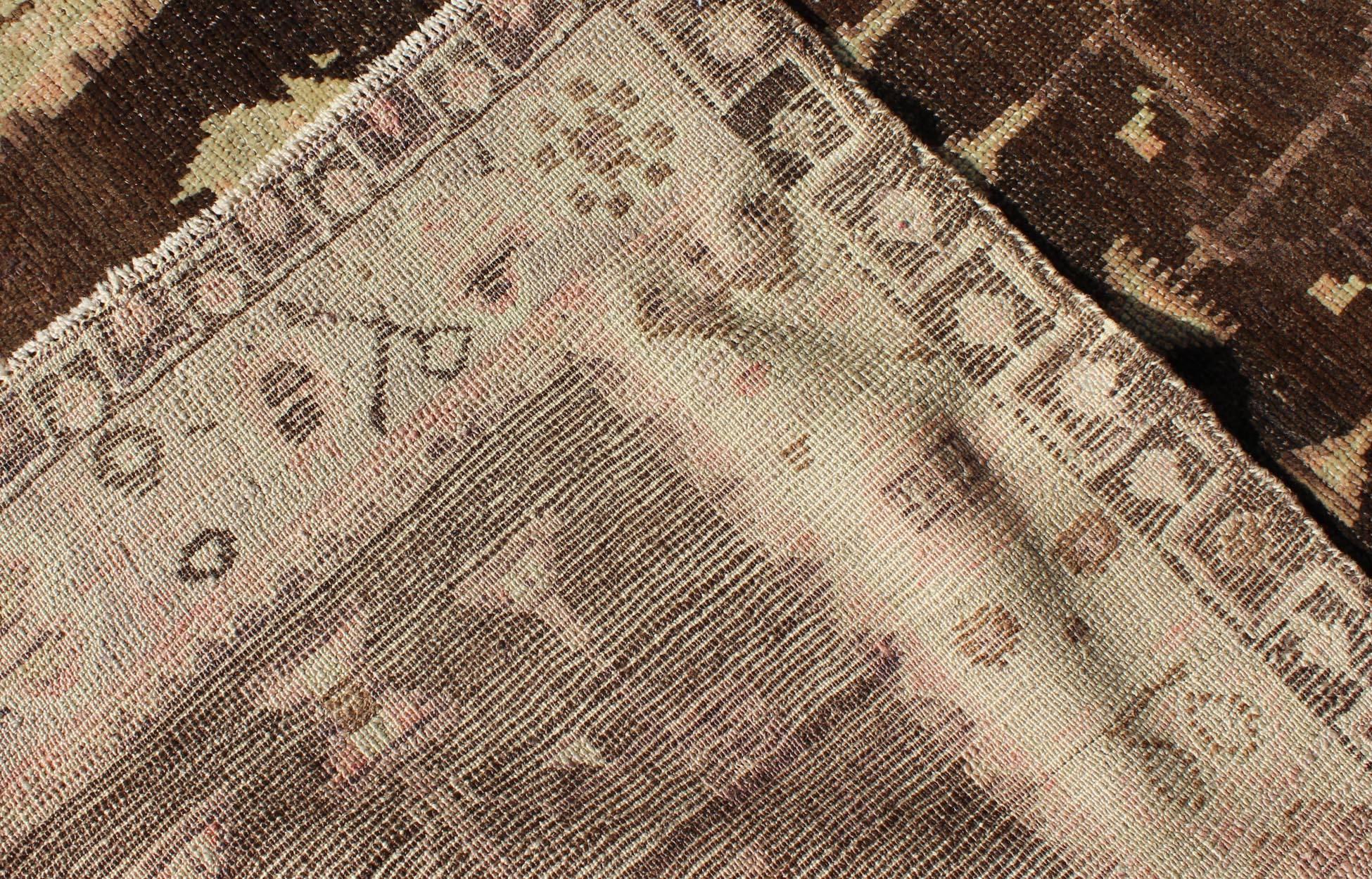 Wool Vintage Turkish Oushak Carpet with Tribal Design Set on Brown Background For Sale