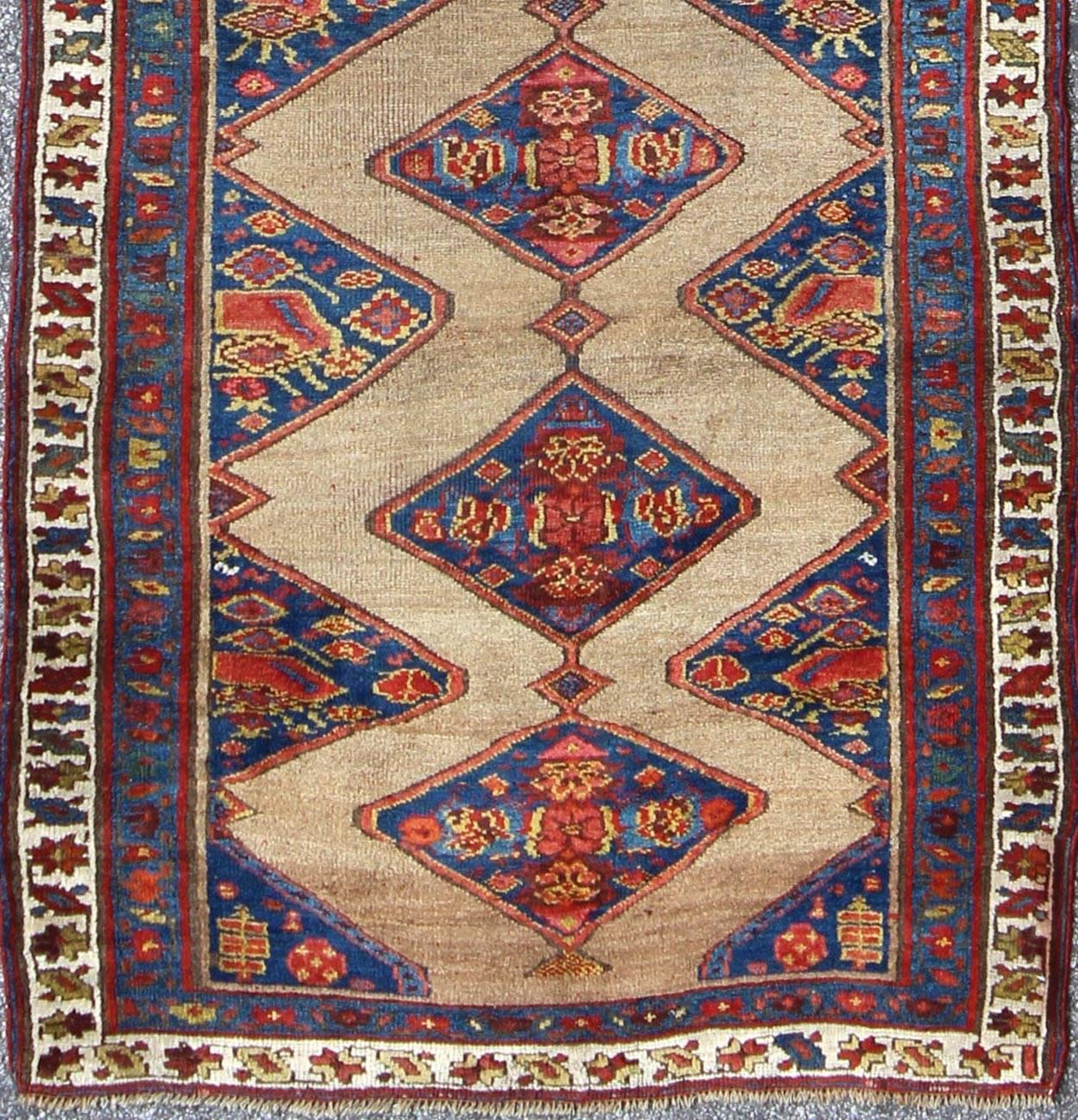 Antique Persian Serab Runner with Camel  rug/20940  origin/ persian

The navy blue and camel field in this piece is decorated with multicolored strap work, lattice work and stylized Boteh and floral elements. Beautifully drawn ivory and blue borders