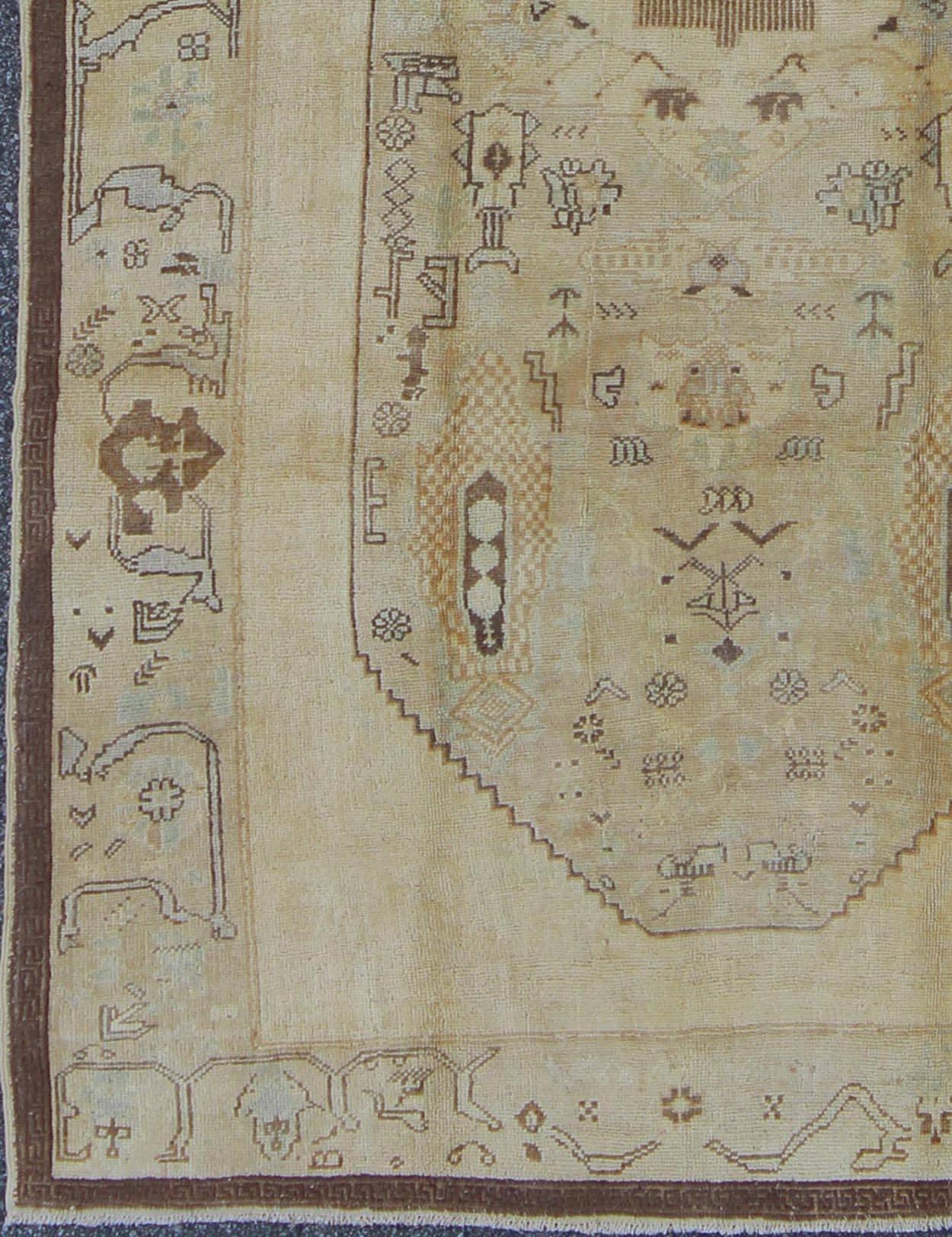 Türkischer Oushak-Teppich mit Stammesfiguren in einer erdigen Farbpalette/de-654  herkunft/Türkei 

Dieser türkische Oushak-Teppich im Vintage-Stil zeichnet sich durch eine erdige Farbmischung und ein kompliziertes, schönes Design aus. Das zentrale