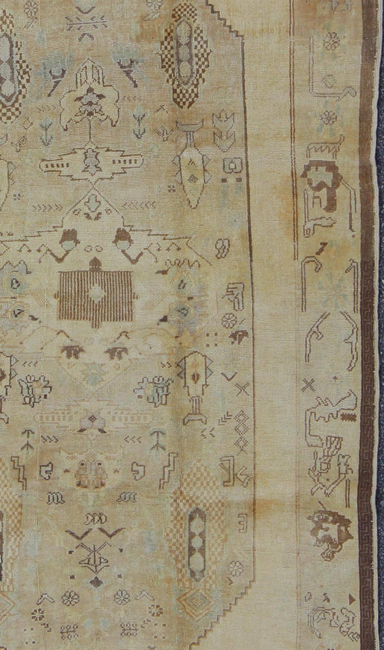 Hand-Knotted Vintage Turkish Oushak Carpet with Tribal Figures in an Earthy Color Palette For Sale
