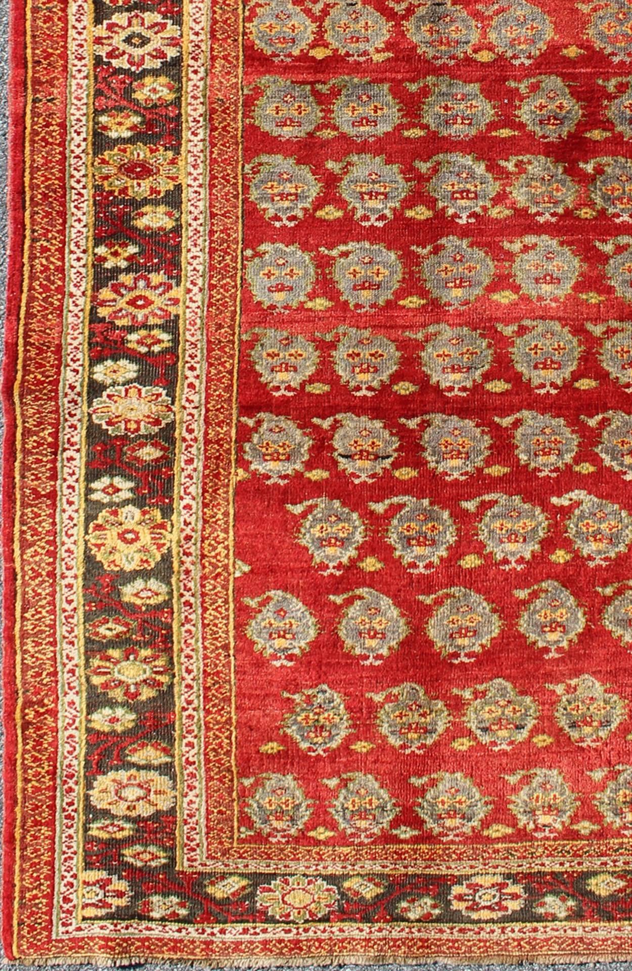 Vintage Turkish Oushak Carpet with All-Over Paisley Design and Central Red Field, Rug/ osm-23.  
This unique Turkish Oushak carpet features an all-over design of intricate paisley shapes set atop a central field of bright red. The entire piece is