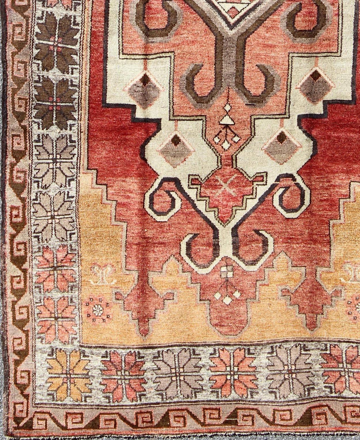This vintage Oushak rug features an intricate and complex design paired with a unique color combination. A geometric-tribal medallion spreads across the central field and is surrounded by multiple defining borders of complementary figures. The