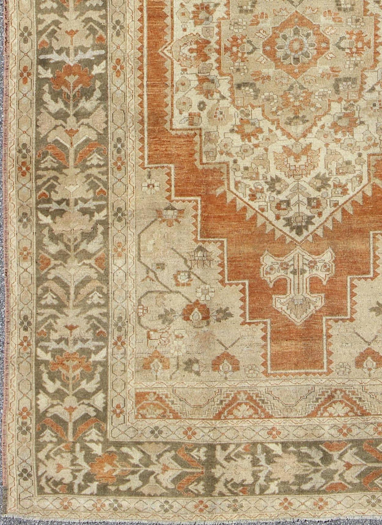 Vintage Turkish Oushak Rug in Rust, Green, Cream, Tape and Neutral Colors.
This beautiful Turkish Oushak rug, handwoven in Turkey, beautifully integrates neutral compositions. This rug features an exquisite geometric design with a large central