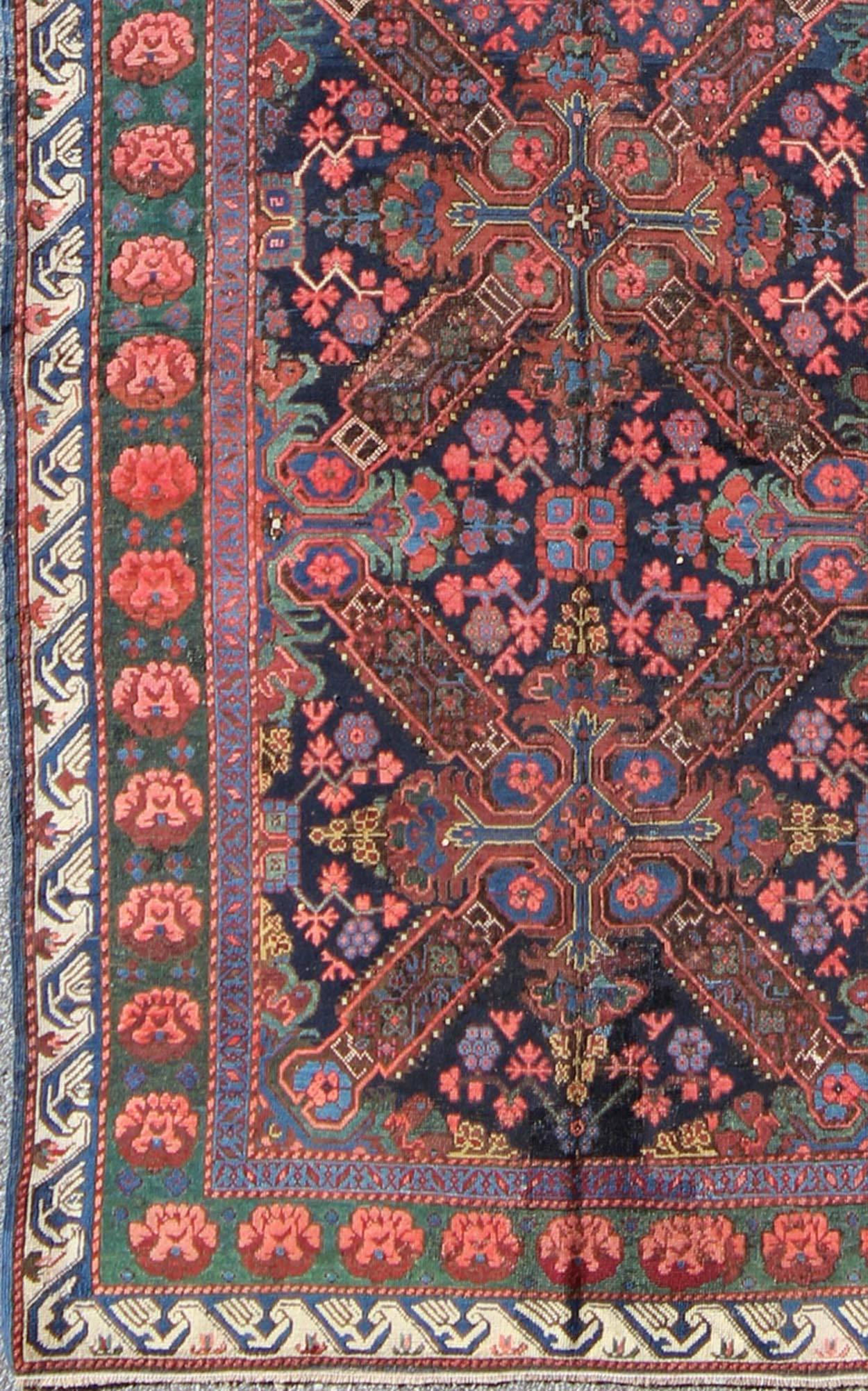 Set on an indigo background this antique 19th Century Seychour Caucasian rug features four intricate medallions composed of delightful rich colors. The entire piece is surrounded by multiple complementary floral borders. This rug features various