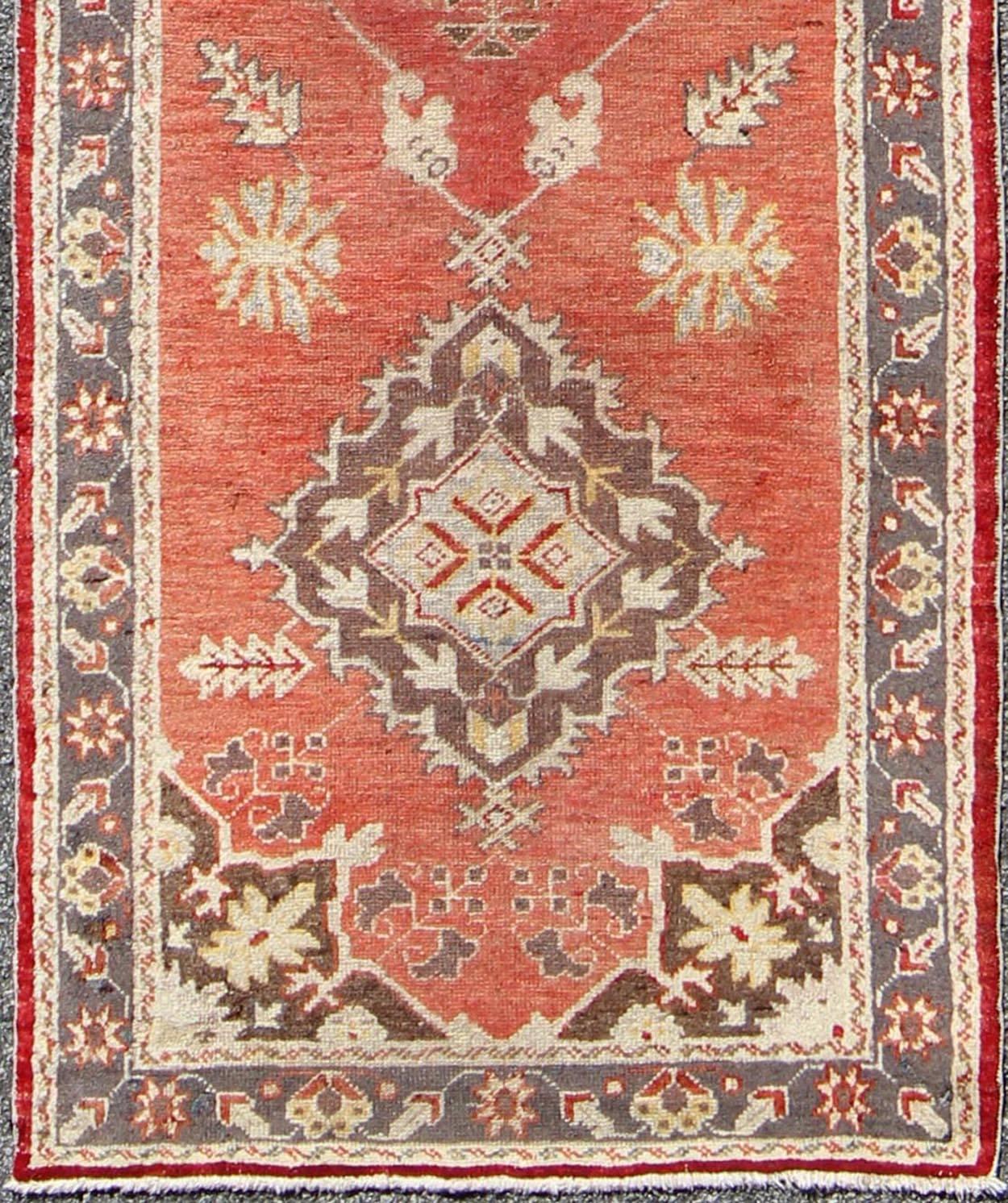 Red and grey Mid-Century vintage Turkish Oushak Runner with floral medallions, rug is 161, country of origin / type: Turkey / Oushak, circa mid-20th century.

This vintage Oushak runner features a unique blend of cheerful colors and an intricately