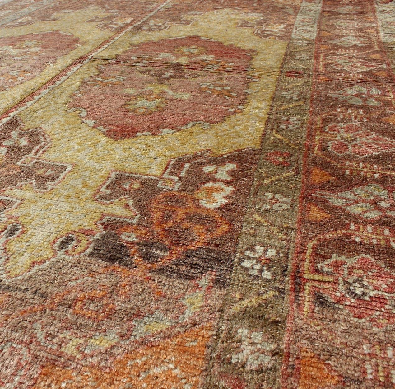 Hand-Knotted Oushak Rug with Two Medallion Panels in Yellow, Brown, Orange and Soft Red For Sale