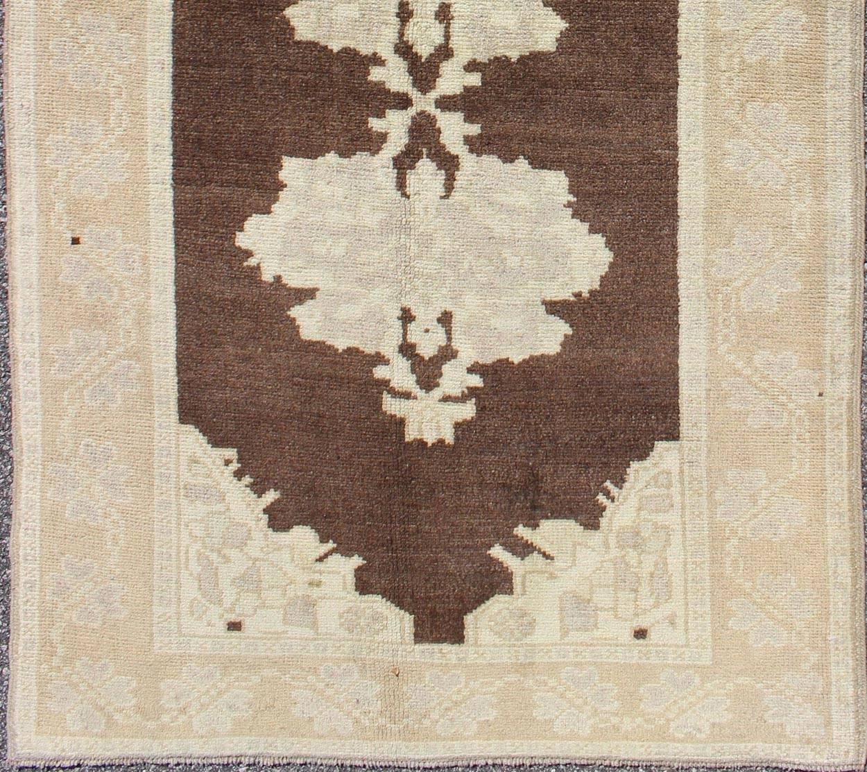 Brown background vintage Turkish Oushak runner with medallions in cream and ivory, rug en-604, country of origin / type: Turkey / Oushak, circa mid-20th century

This beautiful vintage Oushak runner from mid-20th century Turkey features a Classic