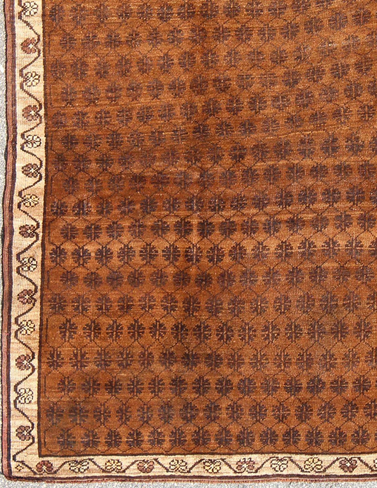 Set on a brown field with an all-over modern/Mid-Century Modern pattern, this beautiful vintage Kars rug (circa mid-20th century) features mocha-colored cross-latch and lattice work. The simple cream border frames the design and consists of