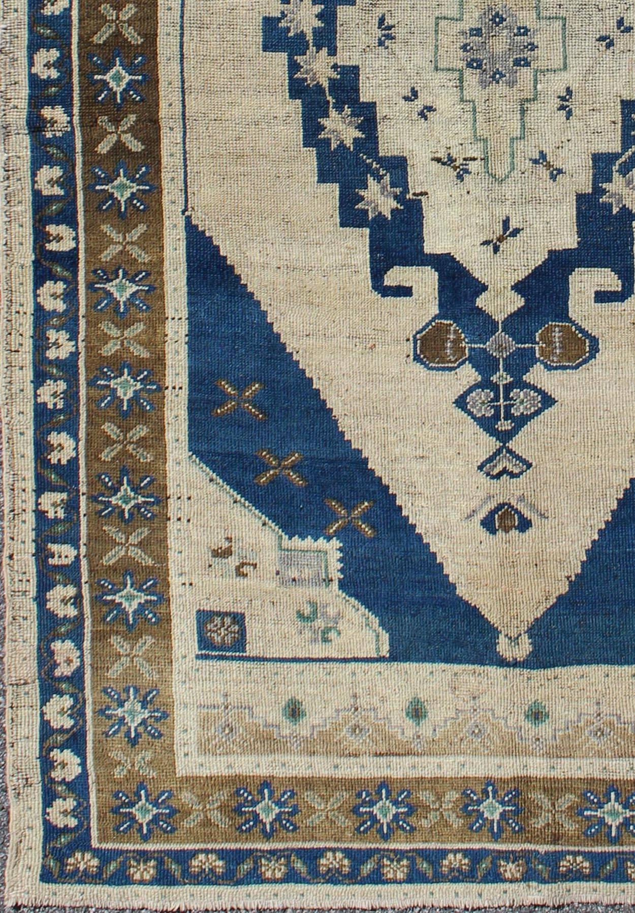 Alfombra turca vintage Oushak en azul marino, marfil, topo y marrón, alfombra tu-9305, país de origen / tipo: Turquía / Oushak, hacia mediados del siglo XX.

Esta alfombra turca Oushak de época (hacia mediados del siglo XX) presenta un diseño de