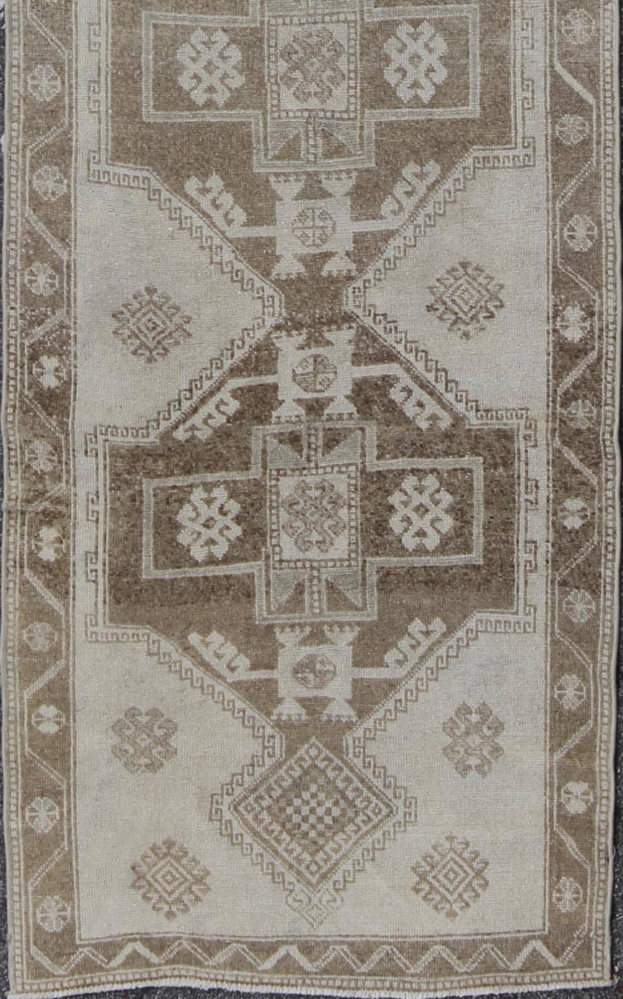 Turkish Oushak gallery runner with four tribal medallions in light gray / brown, rug alk-3649, country of origin / type: Turkey / Oushak, circa mid-20th century

This vintage Turkish Oushak gallery rug (circa mid-20th century) features a unique