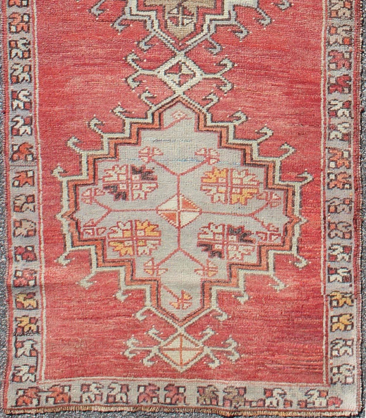 Tribal geometric vintage Turkish Oushak runner with medallions on red background, rug dur-3423, country of origin / type: Turkey / Oushak, circa mid-20th century

This vintage Turkish Oushak gallery rug (circa mid-20th century) features a unique