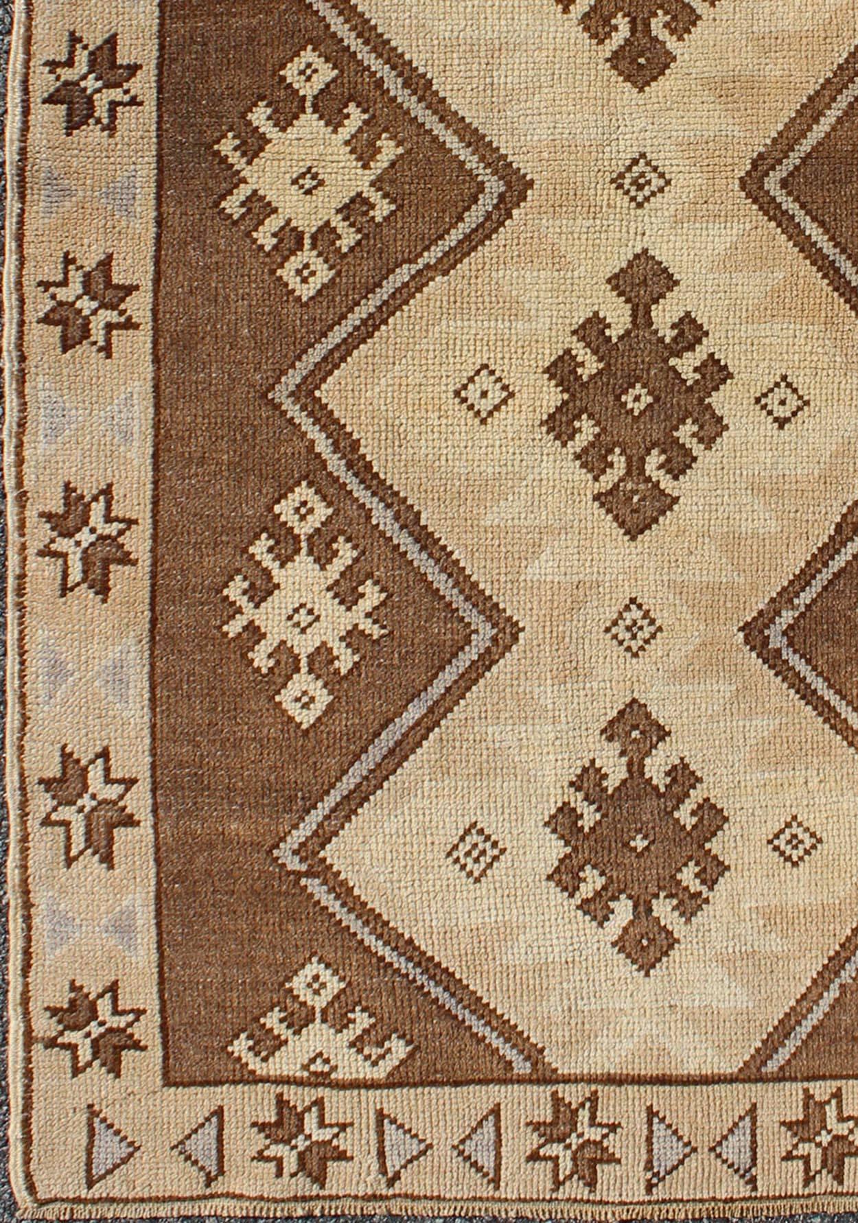 Measures: 2'11'' x 5'6''.   
This vintage Turkish Oushak rug, circa mid-20th century features a unique blend of colors and an intricately beautiful design. The central, interconnected diamond medallions consist of a vertical line of geometric tribal