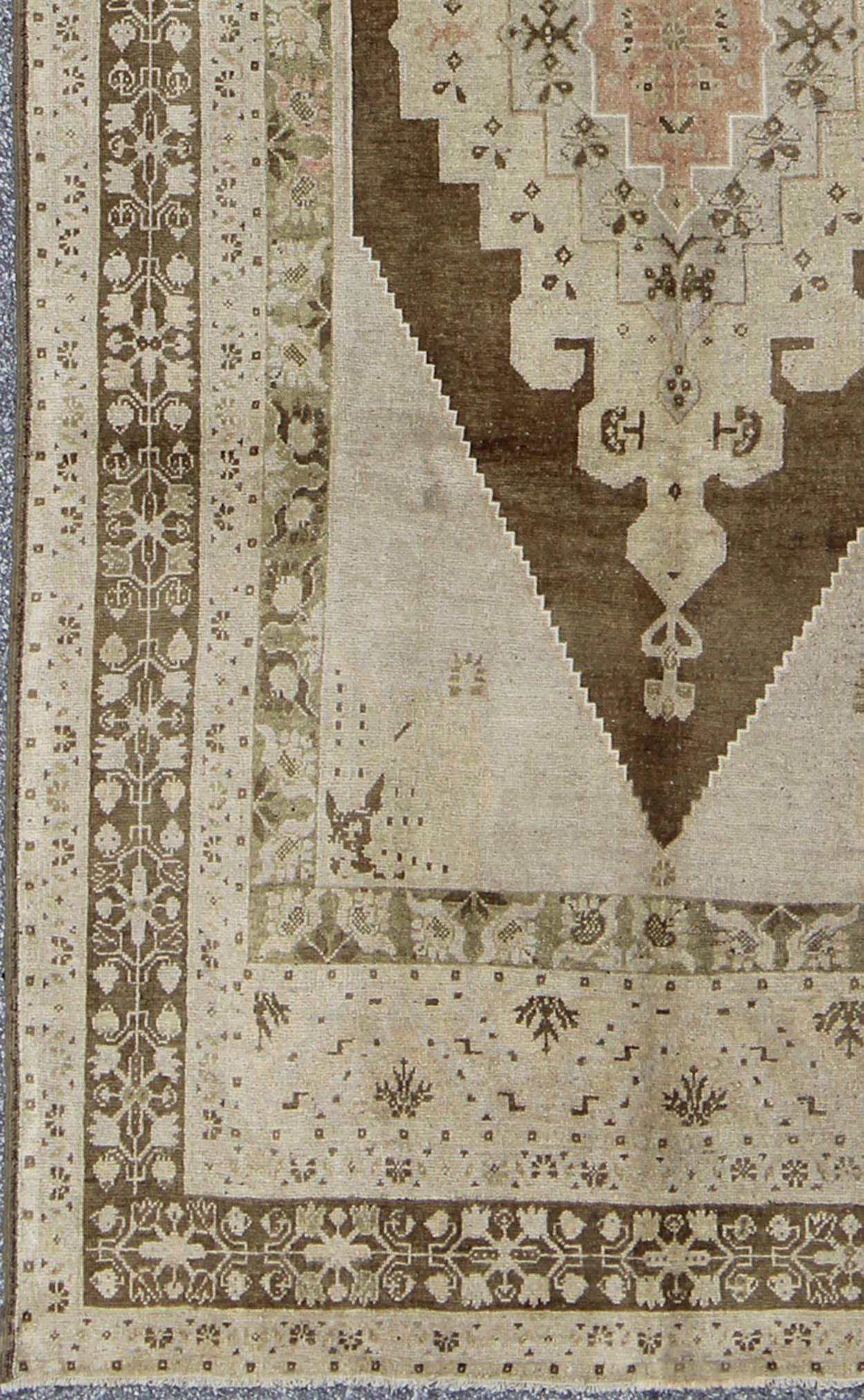 Tappeto vintage turco Oushak con medaglione floreale a più strati in marrone e crema, tappeto ihs-123258, paese d'origine/tipo: Turchia / Oushak, circa metà del XX secolo

Questo tappeto Oushak turco d'epoca (circa metà del XX secolo) presenta un