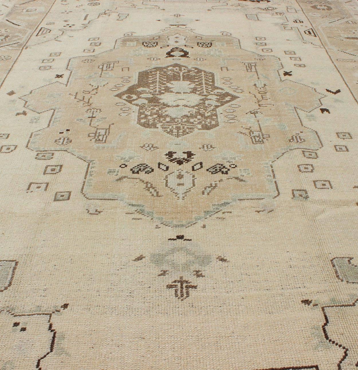 Wool Ivory Background Vintage Turkish Oushak Rug with Tribal Medallion and Motifs For Sale