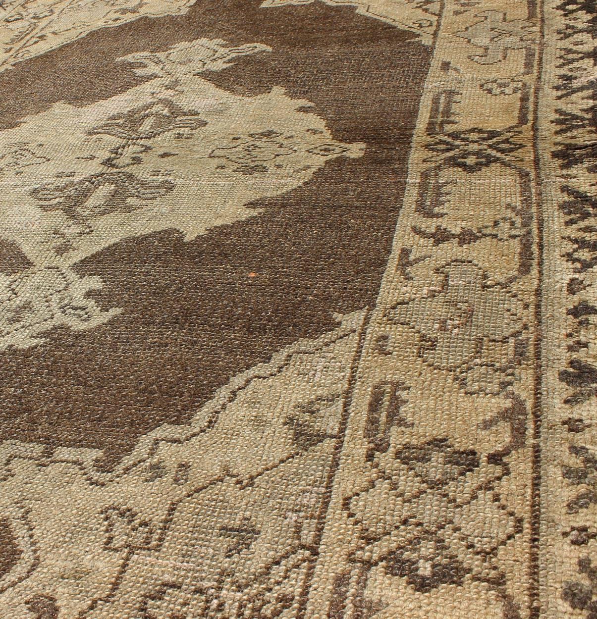 20th Century Chocolate Background Vintage Turkish Oushak Rug with Floral Medallion in Cream For Sale