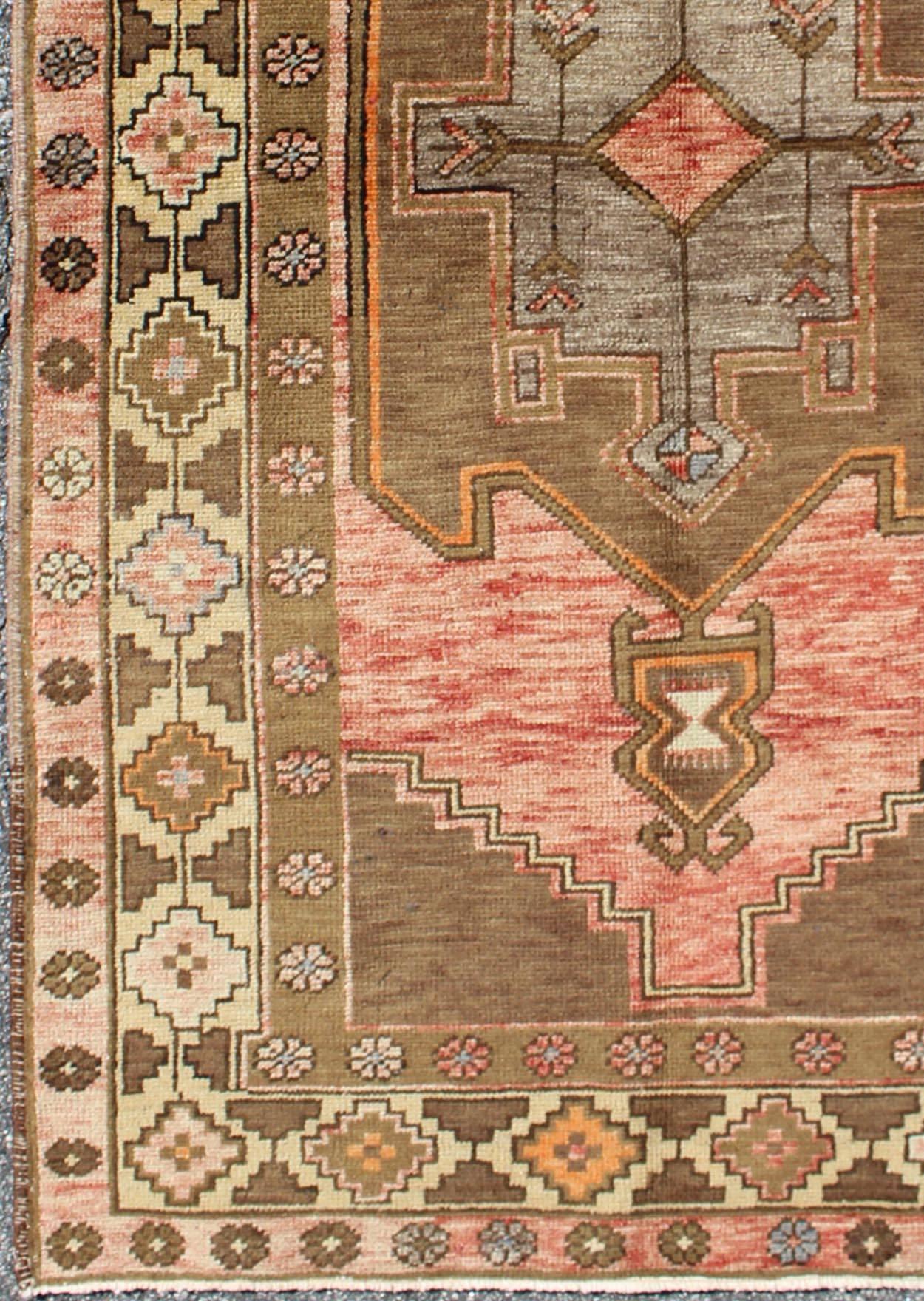 Vieux tapis turc Oushak avec médaillon tribal et bordures florales-géométriques, tapis mte-136546, pays d'origine / type : Turquie / Oushak, vers le milieu du 20e siècle

Ce tapis turc Oushak vintage (vers le milieu du XXe siècle) présente un