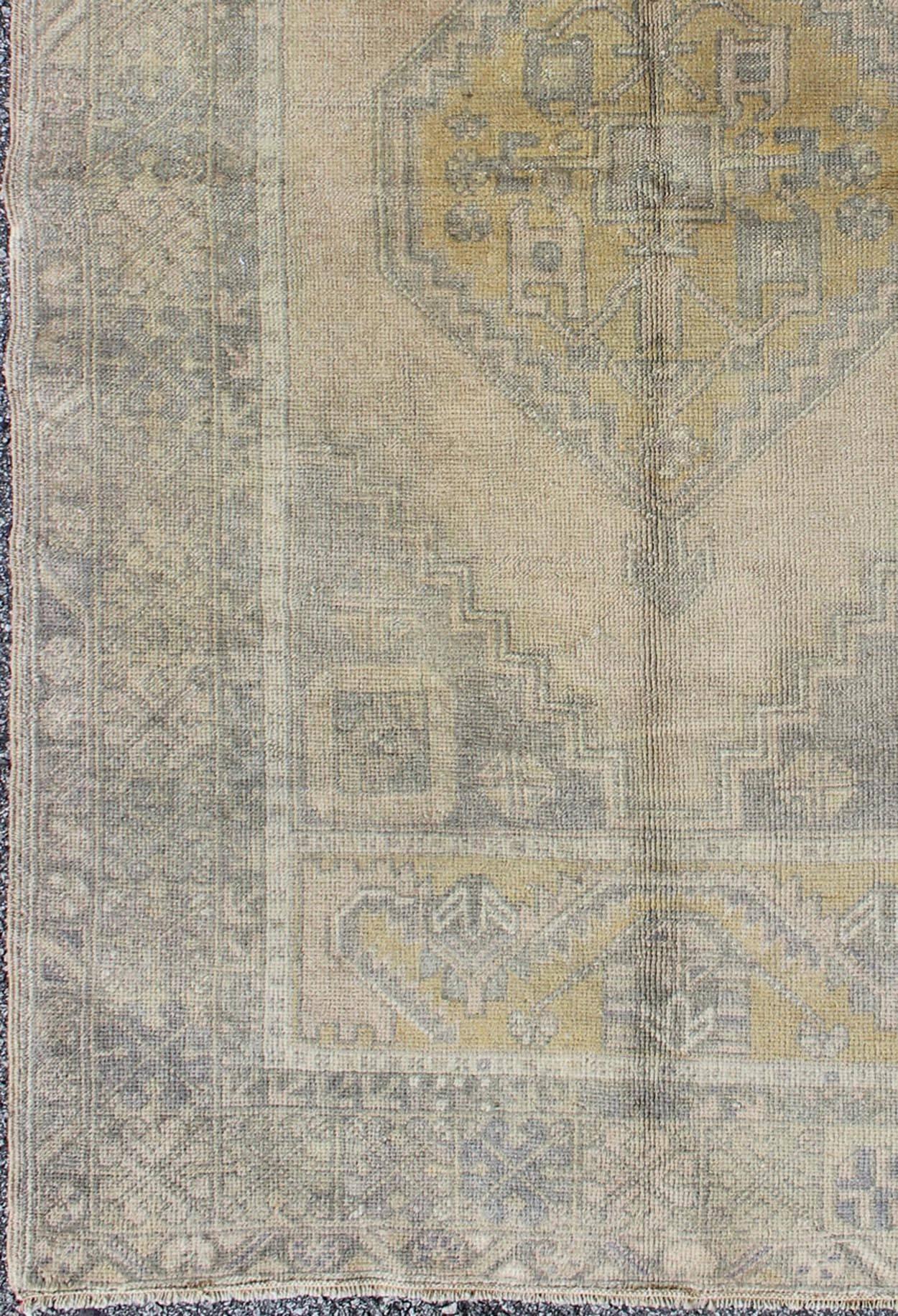 Muted Mid-Century Turkish Oushak rug with tribal geometric medallion design, rug mte-95069, country of origin / type: Turkey / Oushak, circa mid-20th century

This faded vintage Turkish Oushak carpet (circa mid-20th century) features a central