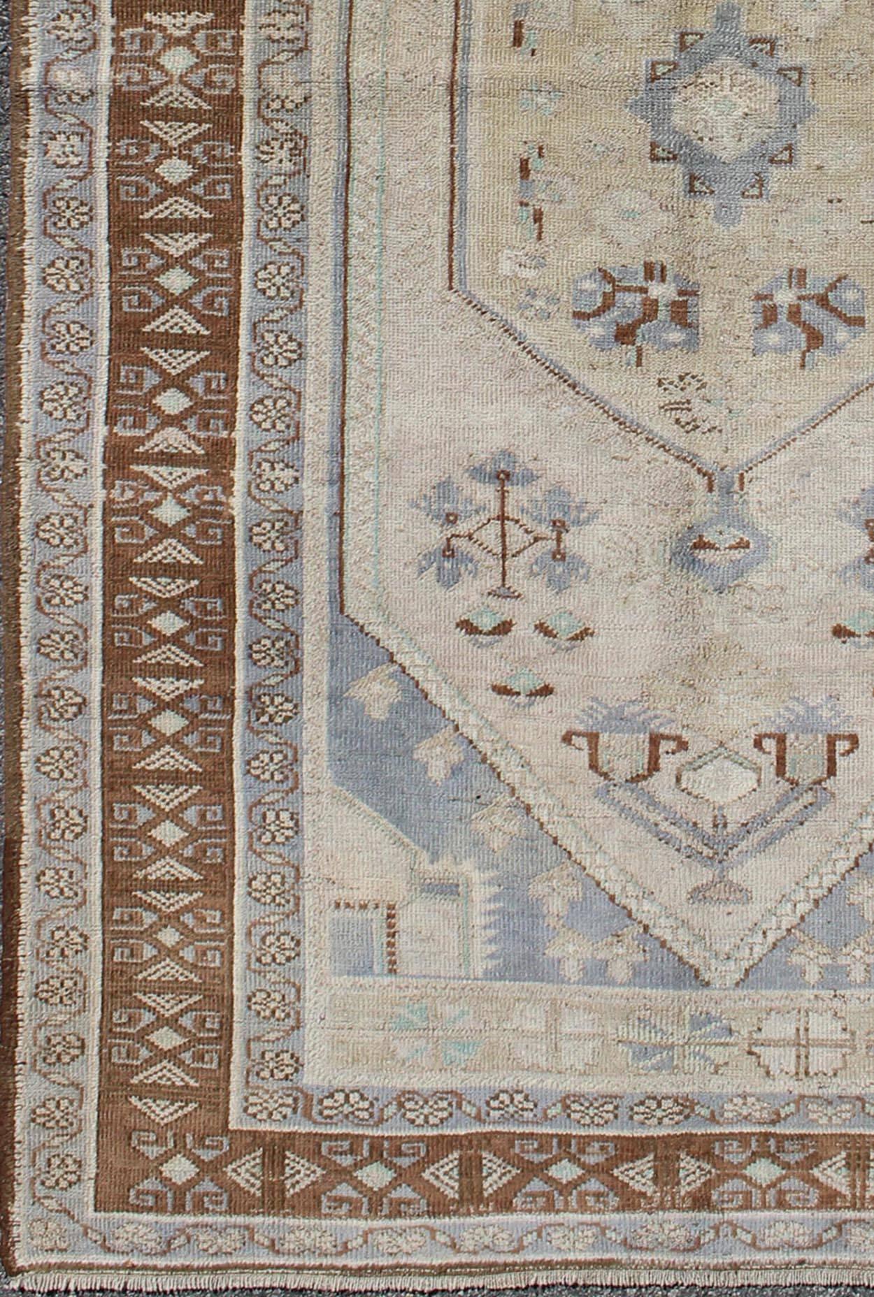 Brown, ivory, and gray vintage Turkish Oushak rug with tribal motifs and medallion, rug mtu-95175, country of origin / type: Turkey / Oushak, circa mid-20th century

This vintage Turkish Oushak rug, (circa mid-20th century) features a unique blend