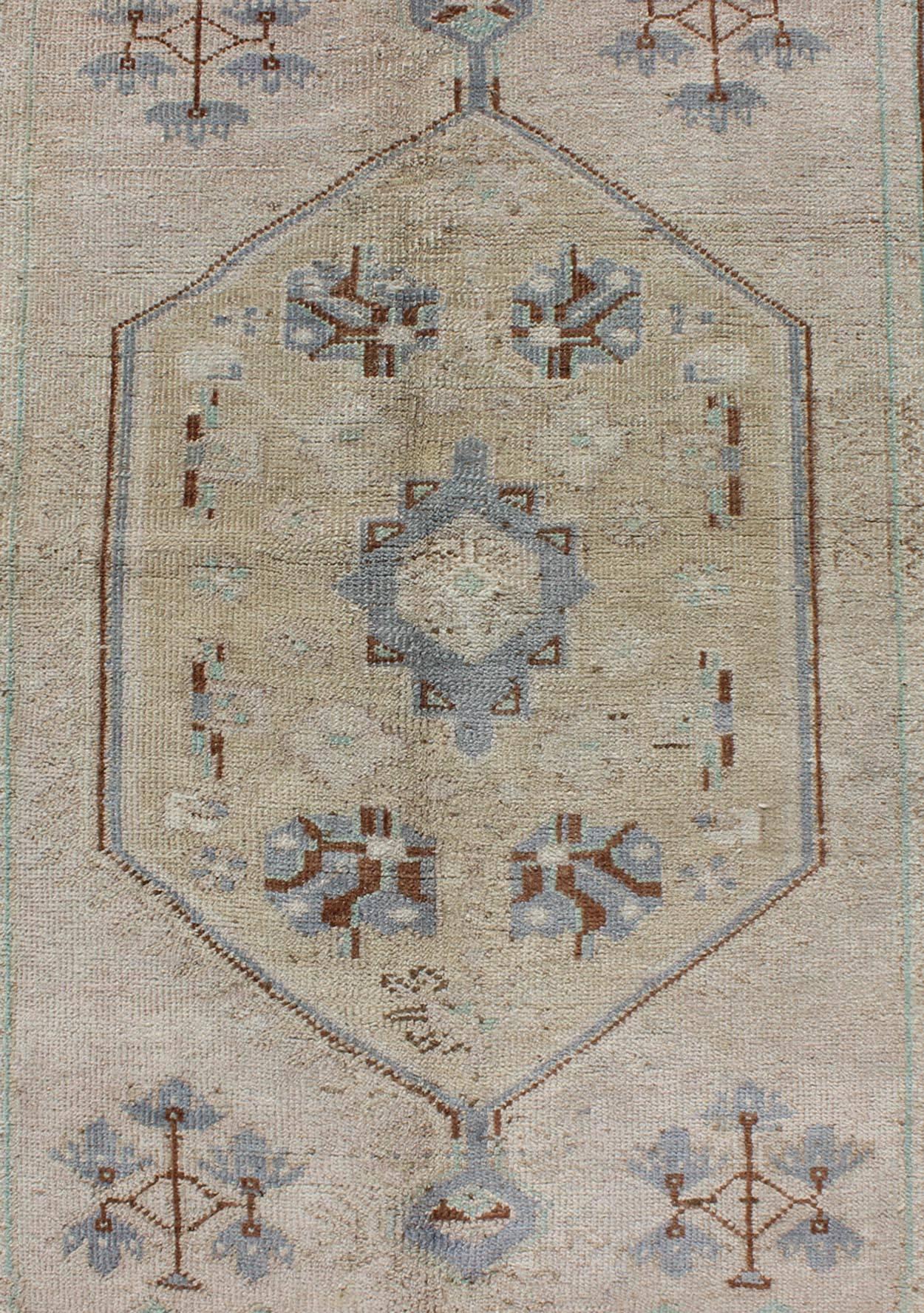 Wool Vintage Turkish Oushak Rug with Tribal Motifs and Medallion For Sale