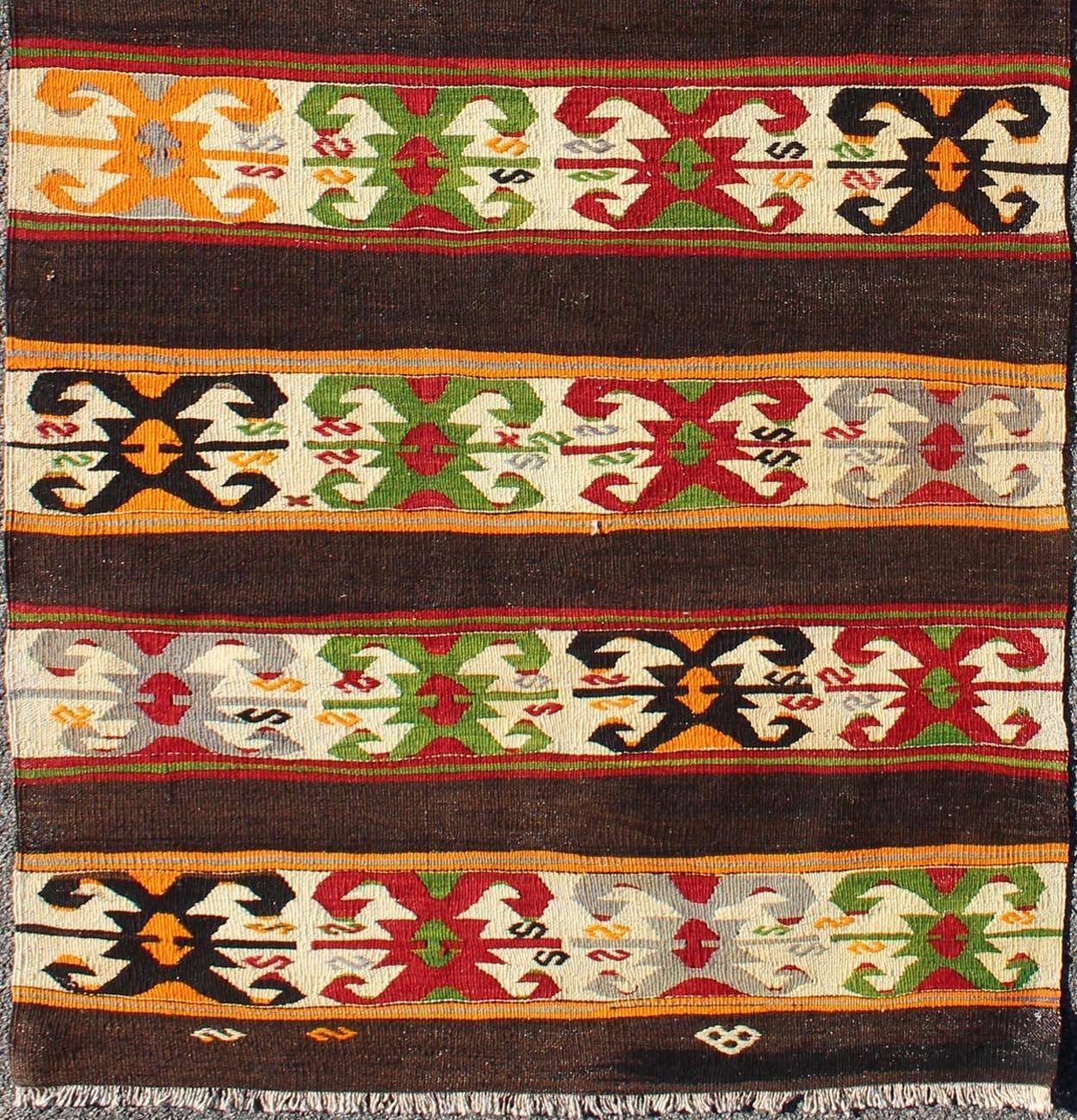 Vintage Turkish Kilim rug with colorful tribal stripes on charcoal background, rug ned-132, country of origin / type: Turkey / Kilim, circa mid-20th century

Featuring tribal elements rendered in a repeating horizontal stripe design, this unique