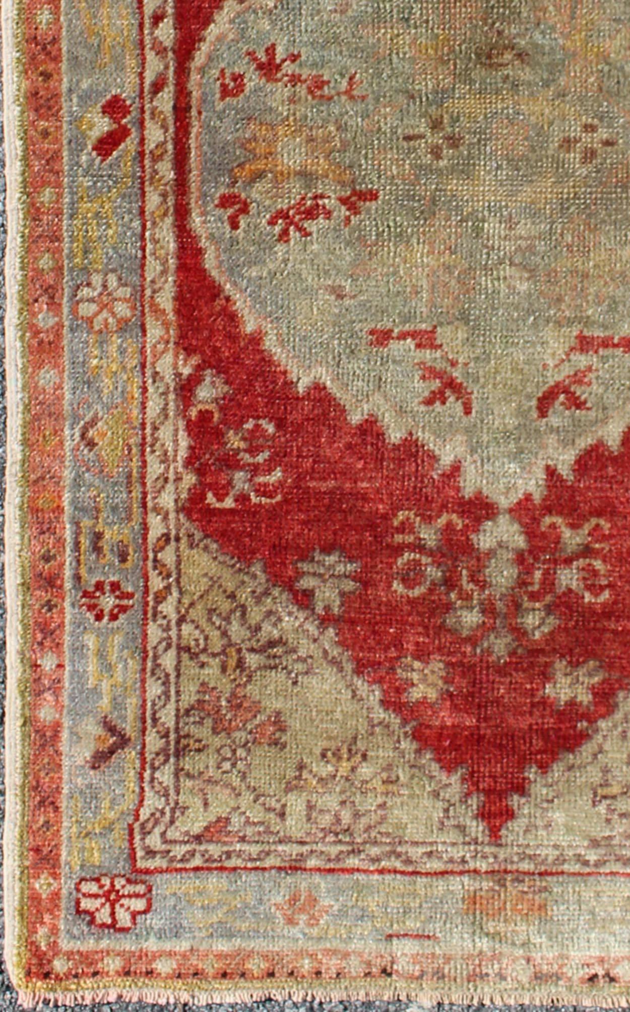 Measures: 2'7'' x 4'6''.
This vintage Turkish Oushak rug (circa mid-20th century) features a unique blend of colors and an intricately beautiful design. The central medallion is complemented by a symmetrical set of floral motifs in the surrounding