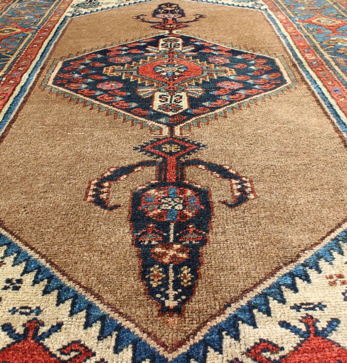 Early 20th Century Antique Persian Serab Rug with Stretched Tribal Medallion in Camel, Blue & Ivory For Sale