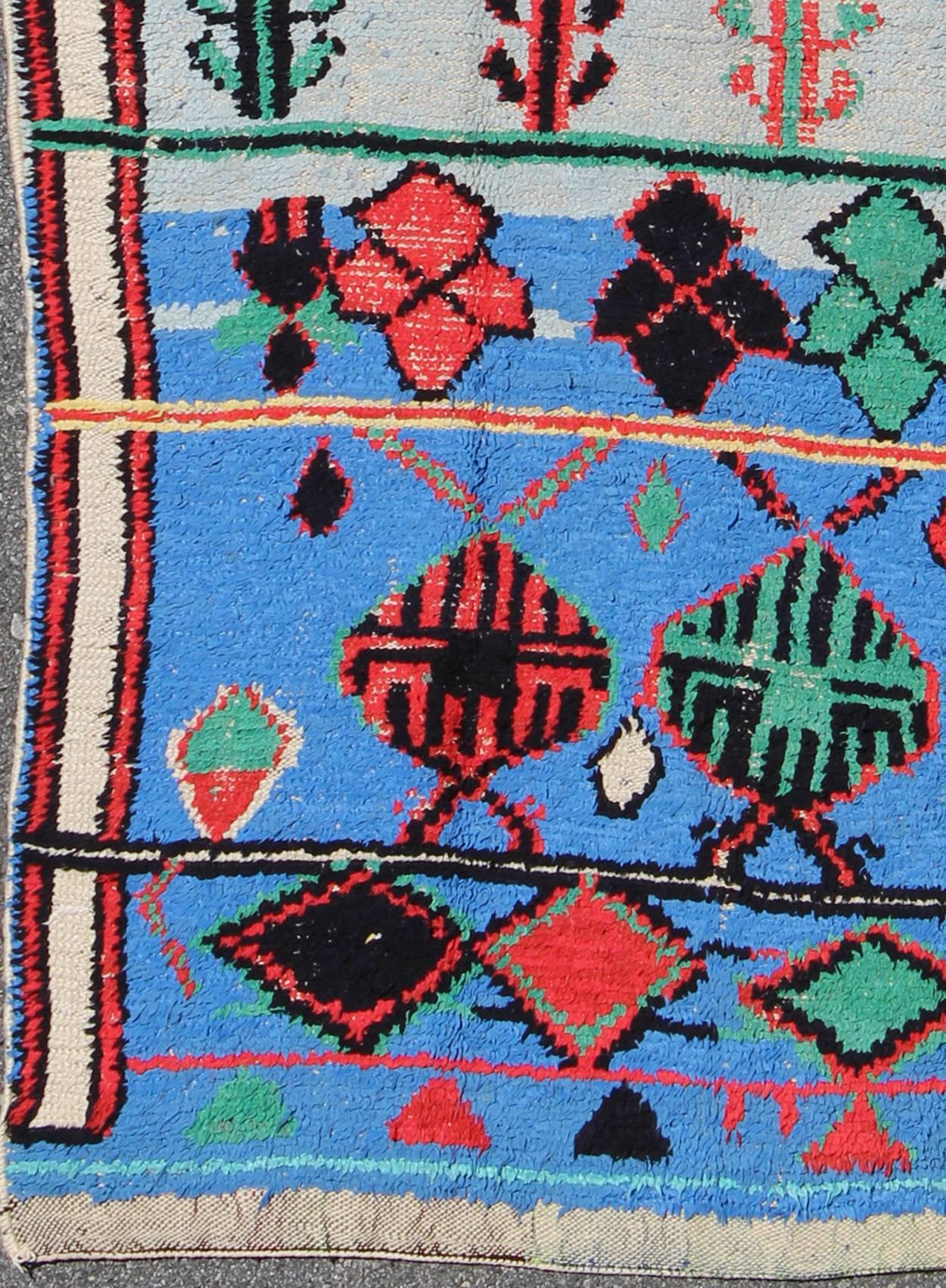 Vivid and vibrant vintage Moroccan rug with scattered tribal motifs, rug EBD-1027, country of origin / type: Morocco / Tribal, circa 1960

This vintage Moroccan carpet, circa 1960 is vivid and vibrant in both color and design. Set on a blue and
