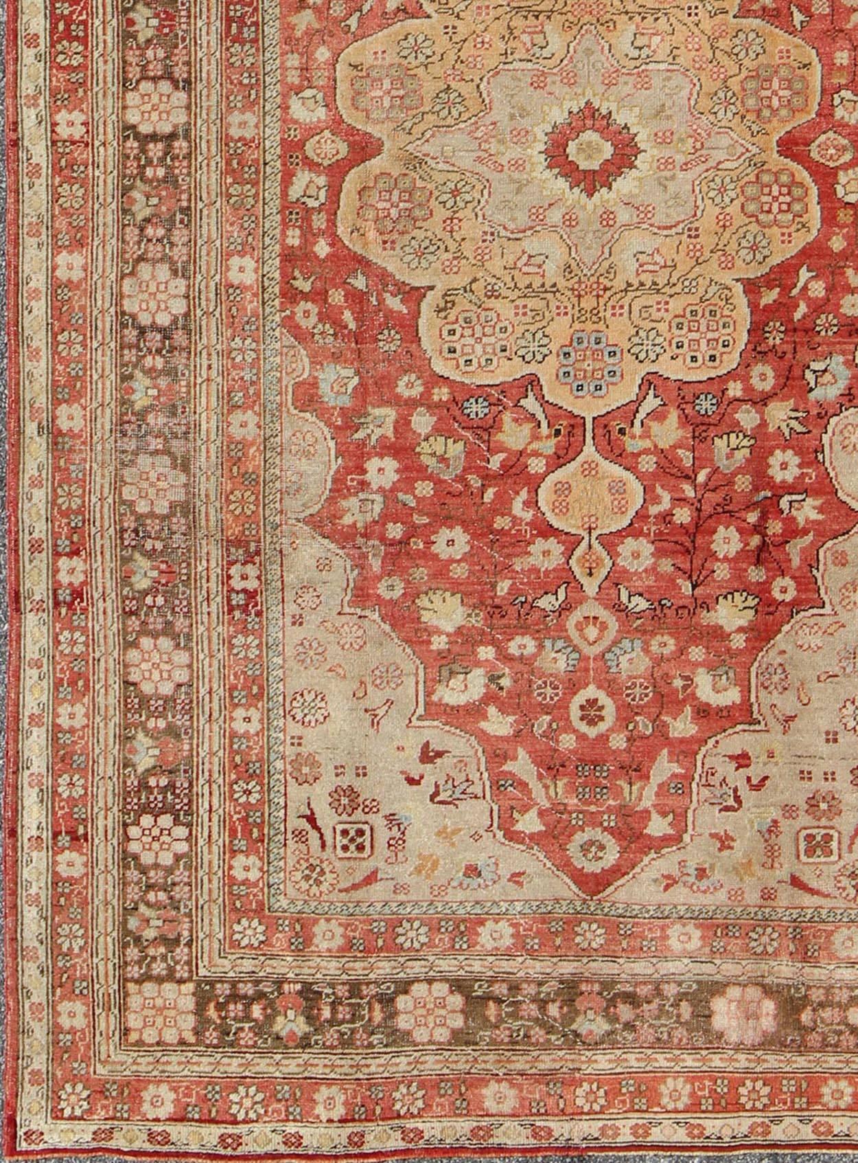 Floral Medallion Turkish Oushak antique rug in red, brown and Tan rug el-14703, country of origin / type: Turkey / Oushak, circa 1920

This stunning antique Turkish Oushak carpet (circa 1920) features a central medallion and floral motifs throughout