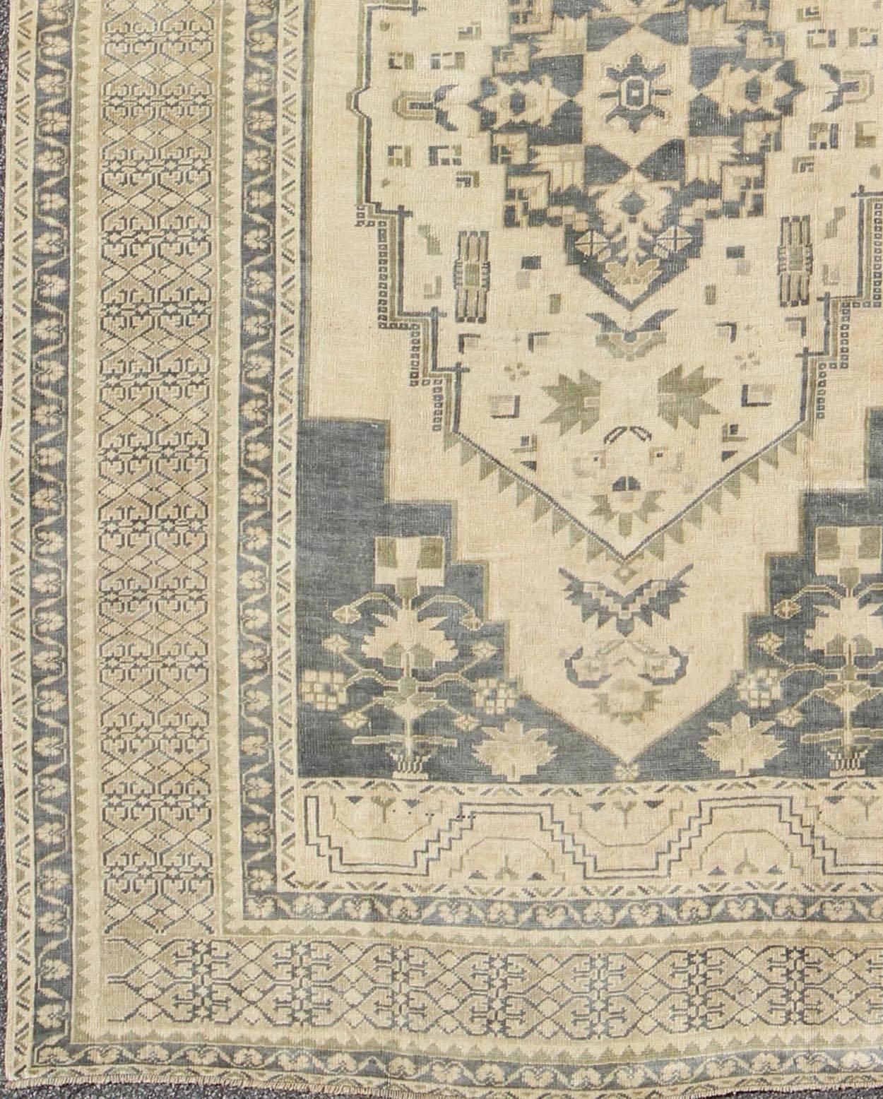 Dark grey blue and cream mid-20th century Turkish Oushak rug with medallion, cornices, rug en-227, country of origin / type: Turkey / Oushak, circa 1940

This beautiful vintage rug from mid-20th century Turkey features a intricate design, which is