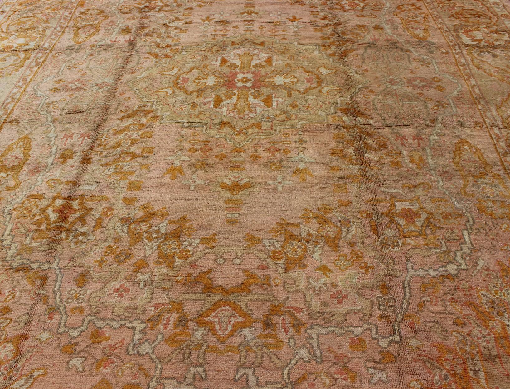 Inizio XX secolo Tappeto antico Oushak con motivi floreali in rosa, arancione e verde chiaro in vendita