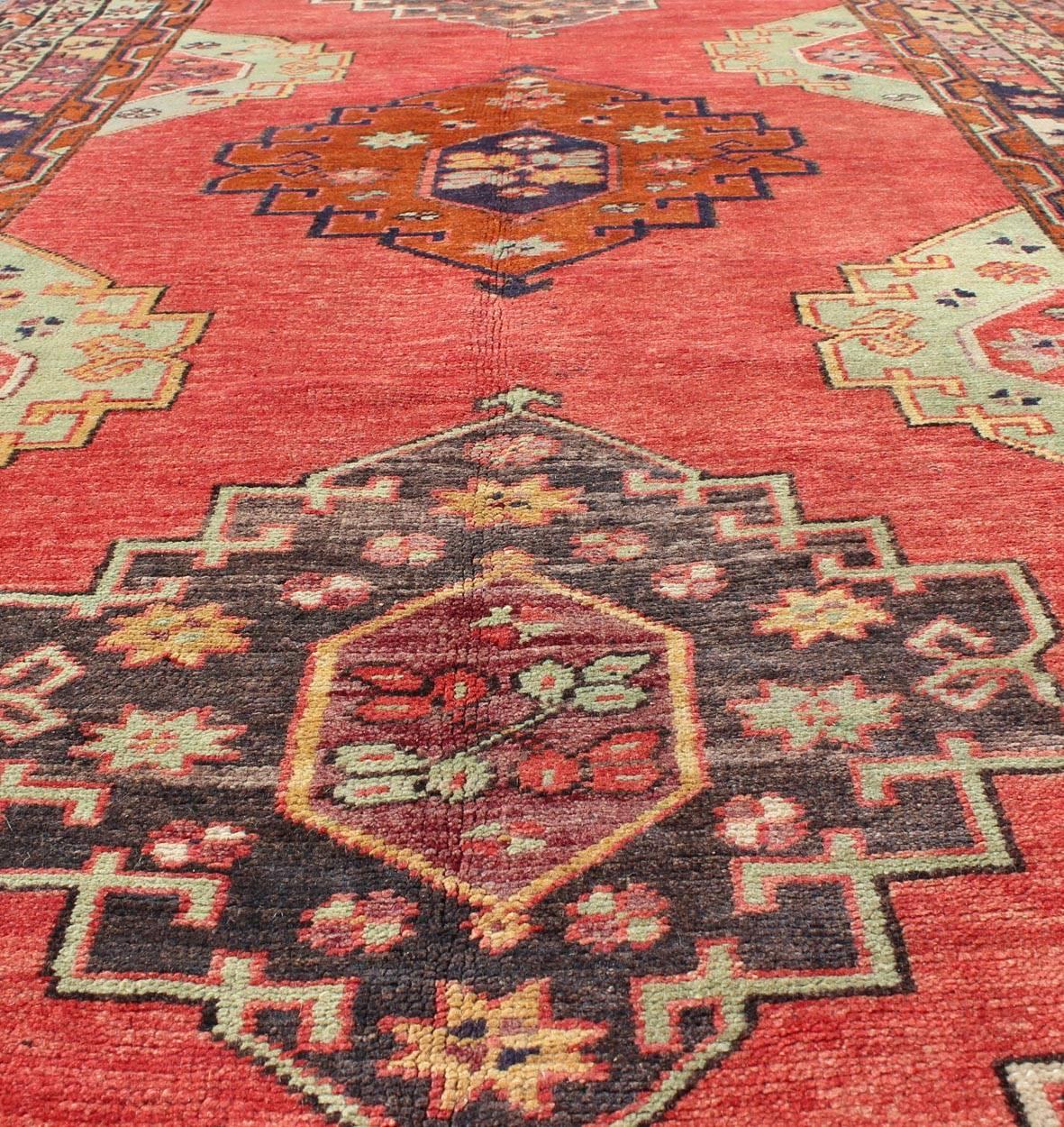 Wool Red Field Vintage Turkish Oushak Rug with Vertical Geometric Medallions For Sale