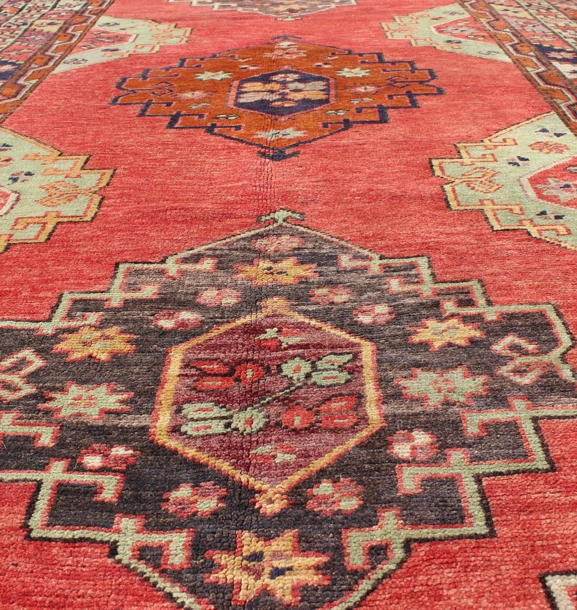 Türkischer Oushak-Teppich mit rotem Feld und vertikalen geometrischen Medaillons im Vintage-Stil (Wolle) im Angebot