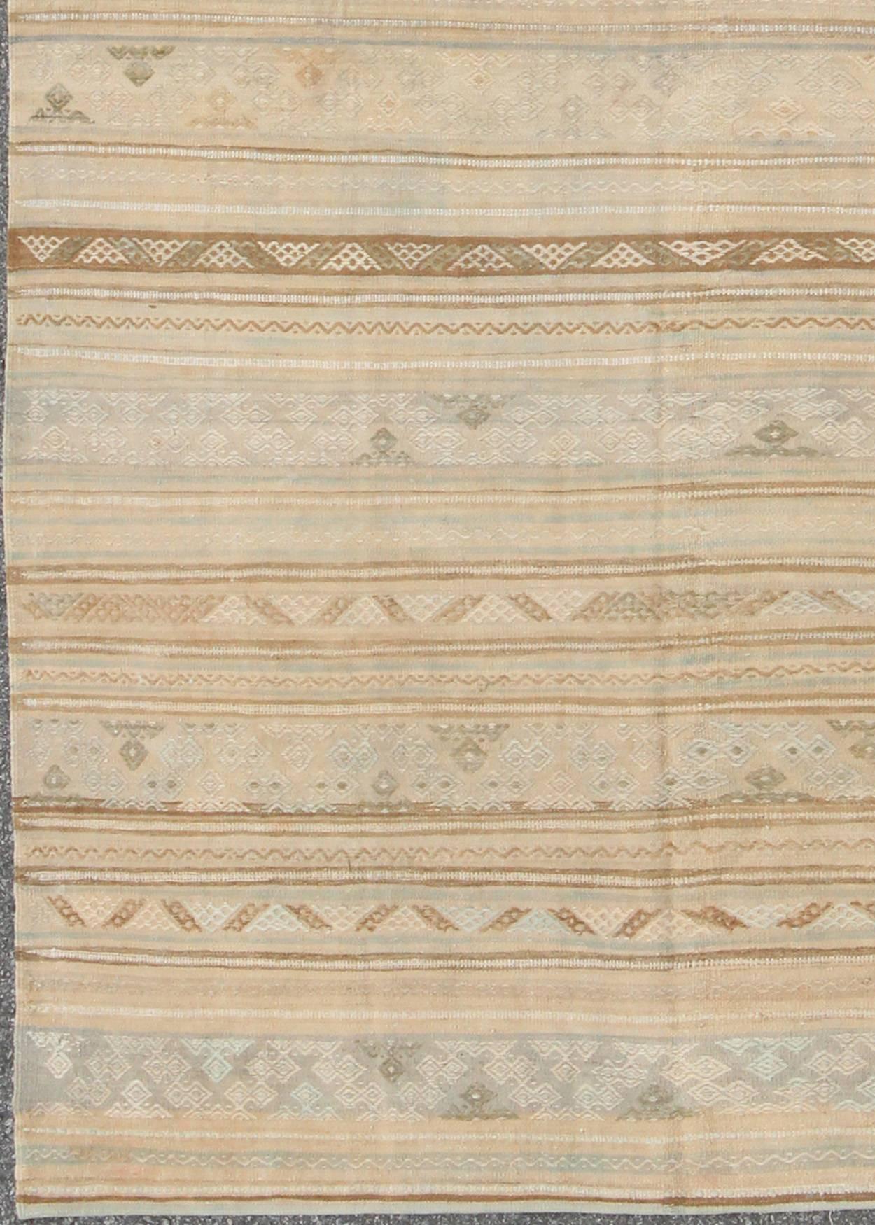 Neutral stripes vintage Turkish Kilim rug with assorted geometric tribal shapes, rug en-141092, country of origin / type: turkey / Kilim, circa mid-20th century

Featuring geometric tribal shapes rendered in a repeating horizontal stripe design,