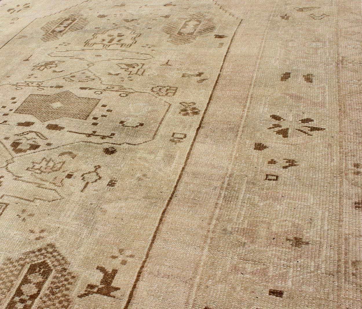 Mid-20th Century Vintage Turkish Oushak Rug with Tribal Motifs in Shades of Brown and Cream For Sale