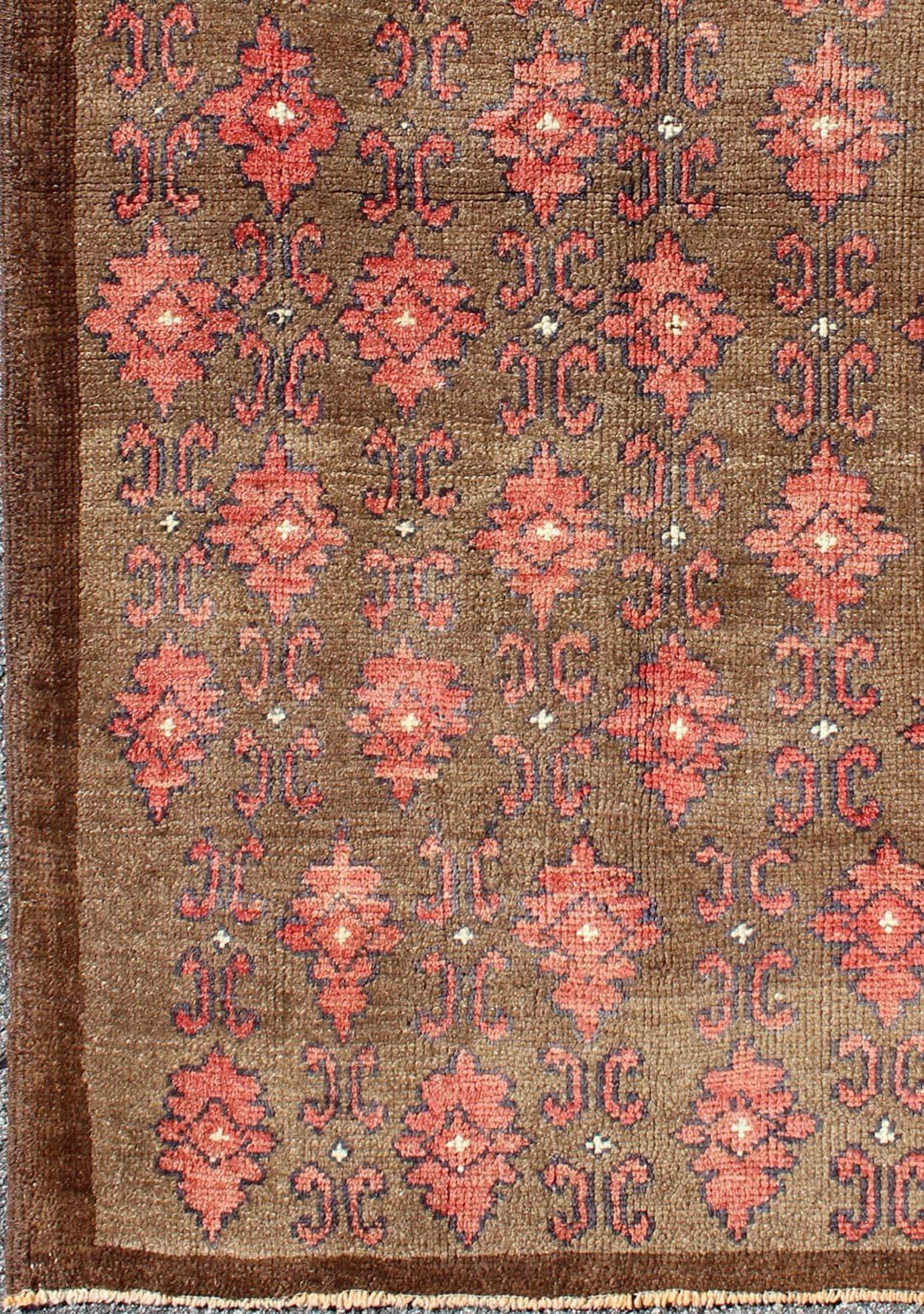 Red and brown vintage Turkish Oushak rug with repeating vertical motif design, rug en-115273, country of origin / type: Turkey / Oushak, circa 1950

Set on a dark mocha brown field with an all-over pattern, this beautiful midcentury Turkish Oushak