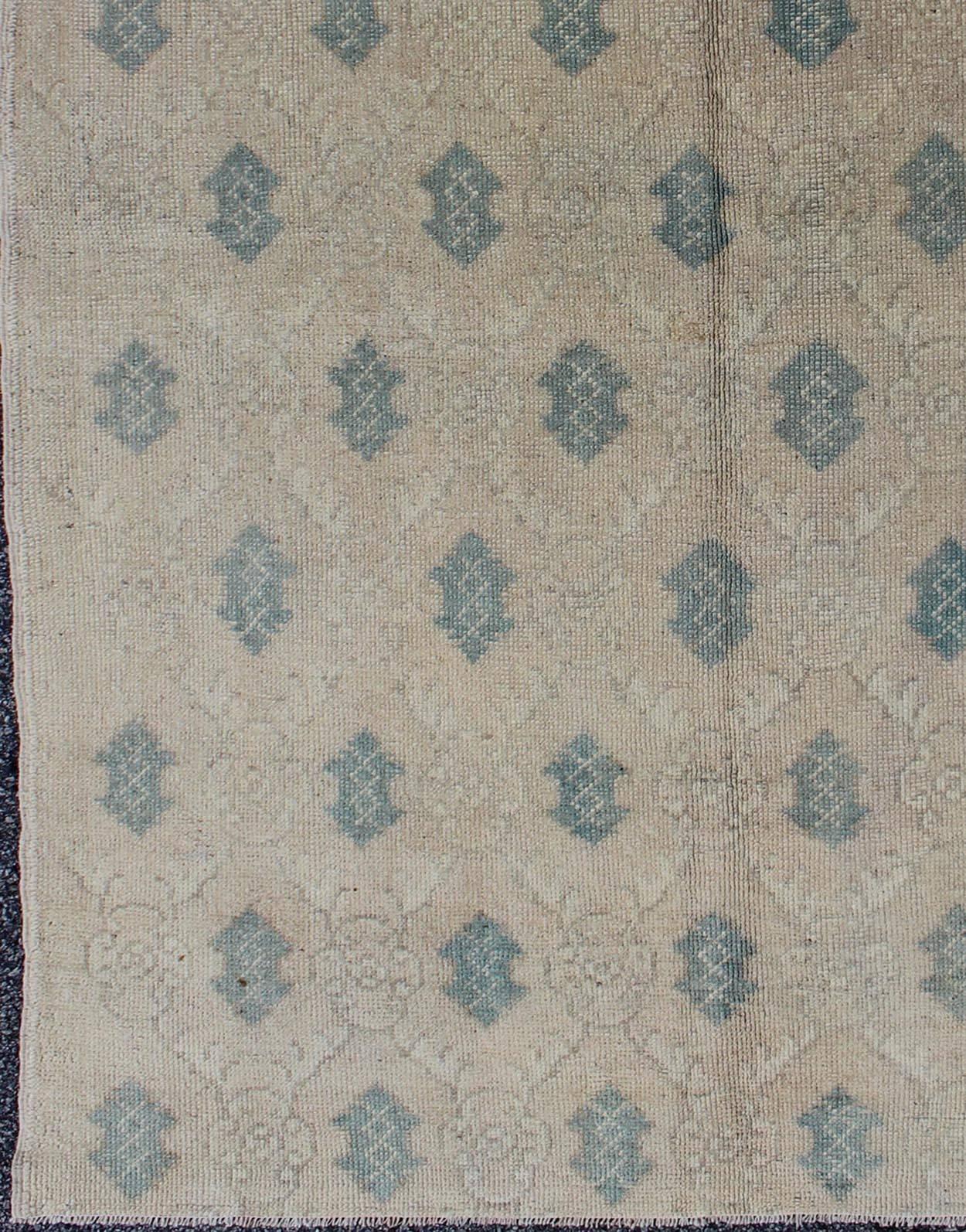 All-over design vintage Turkish Oushak rug in shades of cream and teal, rug en-912, country of origin / type: Turkey / Oushak, circa 1940

This vintage Turkish Oushak carpet (circa mid-20th century) features an all-over latticework design with