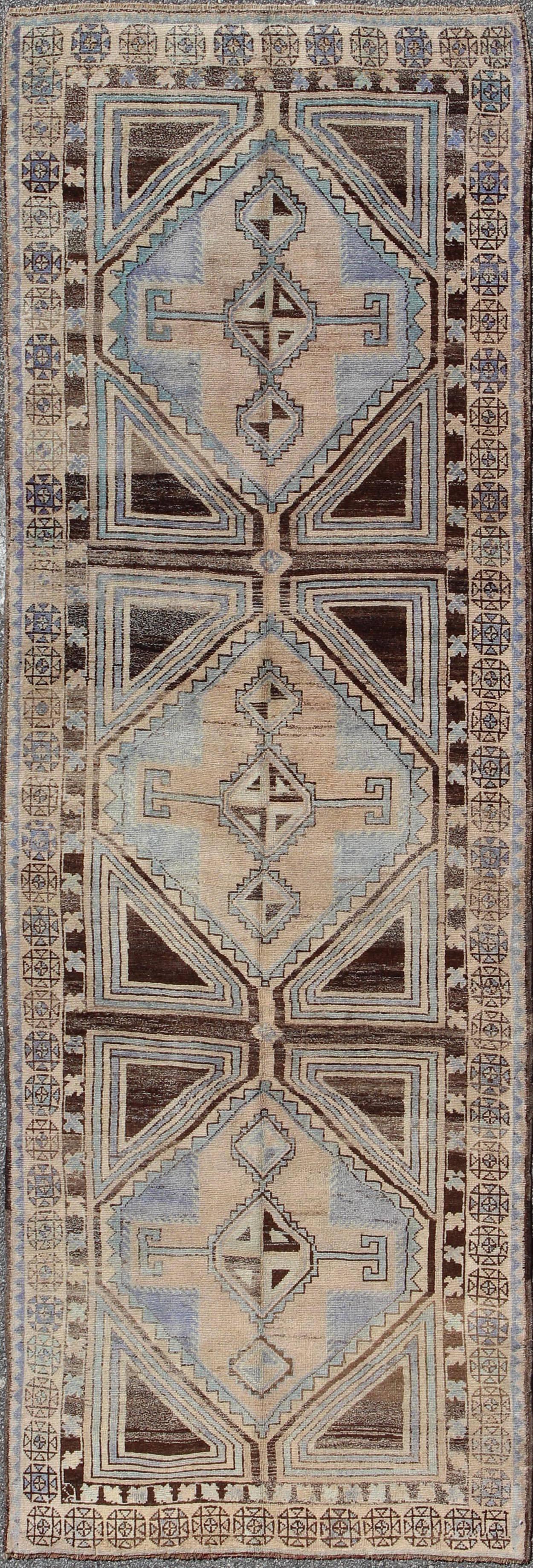 This stunning Turkish Oushak features three central medallions in dark brown, light taupe, camel and blue colors. The bold geometric design of the rug is enhanced by the use of lighter colors. 
Measures: 4.3 x 12.3.