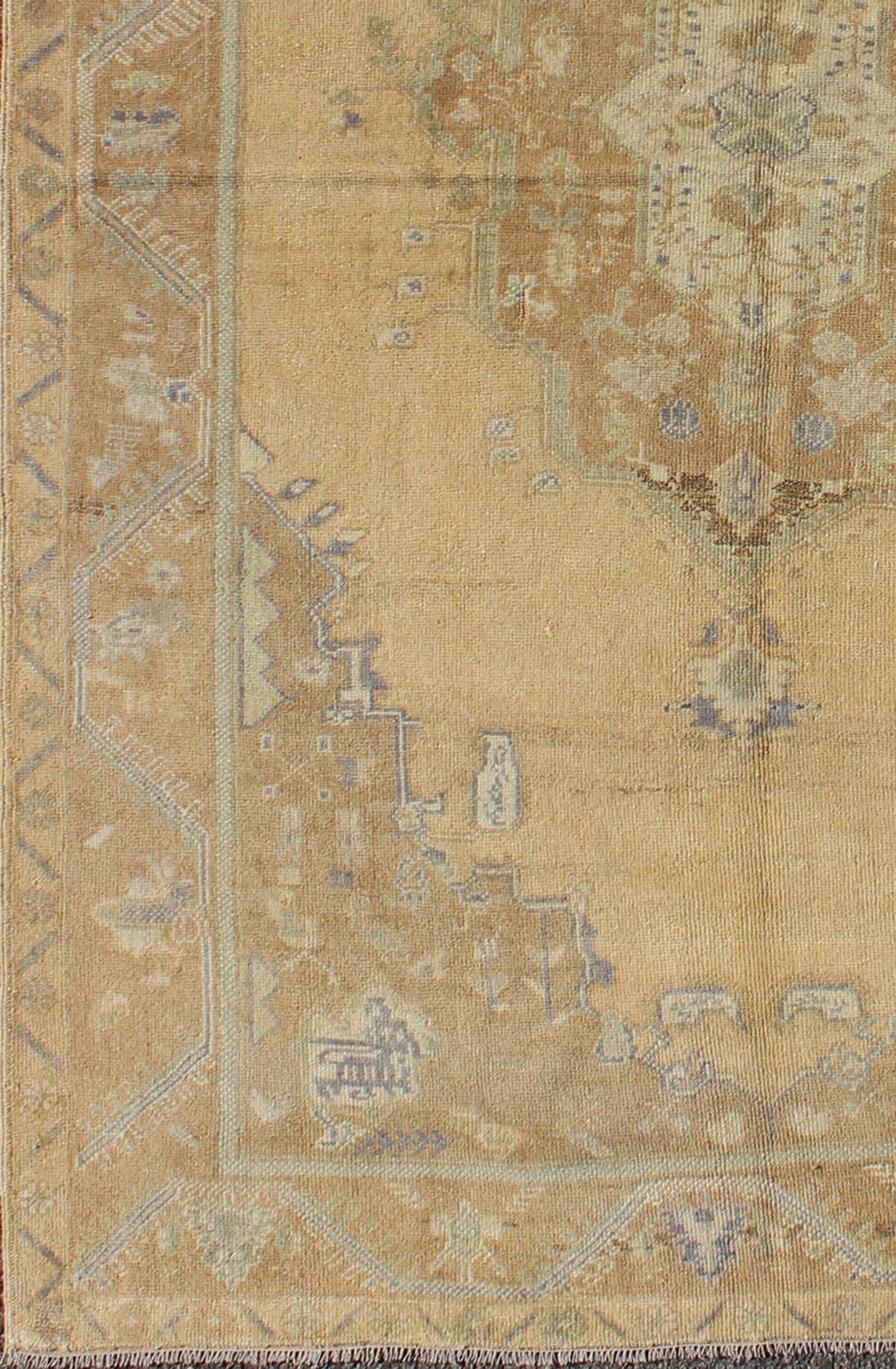 Faded vintage Turkish Oushak rug with layered medallion in shades of cream, yellow and light brown, rug en-657, country of origin / type: Turkey / Oushak, circa 1940

This Oushak rug features a unique blend of colors and an intricately beautiful