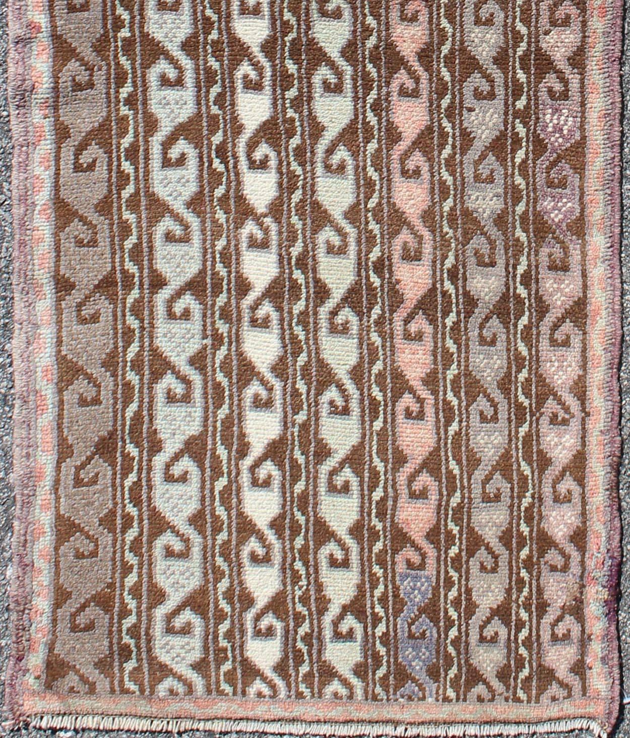 Brown and pastel-colored vintage Turkish Oushak runner with vining geometrics, rug en-957, country of origin / type: Turkey / Oushak, circa 1930

This vintage Turkish gallery runner (circa 1930) features a unique blend of colors and an intricately