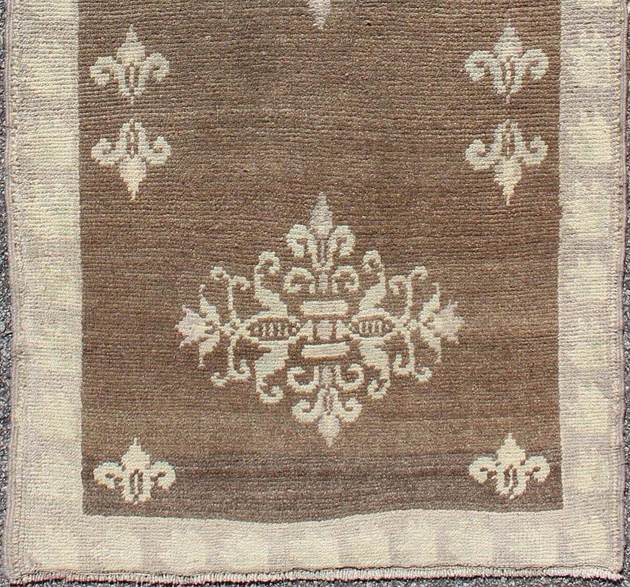Brown midcentury Turkish Tulu runner with ivory blossoming medallions, rug en-112932, country of origin / type: Turkey / Tulu, circa mid-20th century.

This vintage Tulu runner contains three ivory blossoming medallions laid across a solid brown
