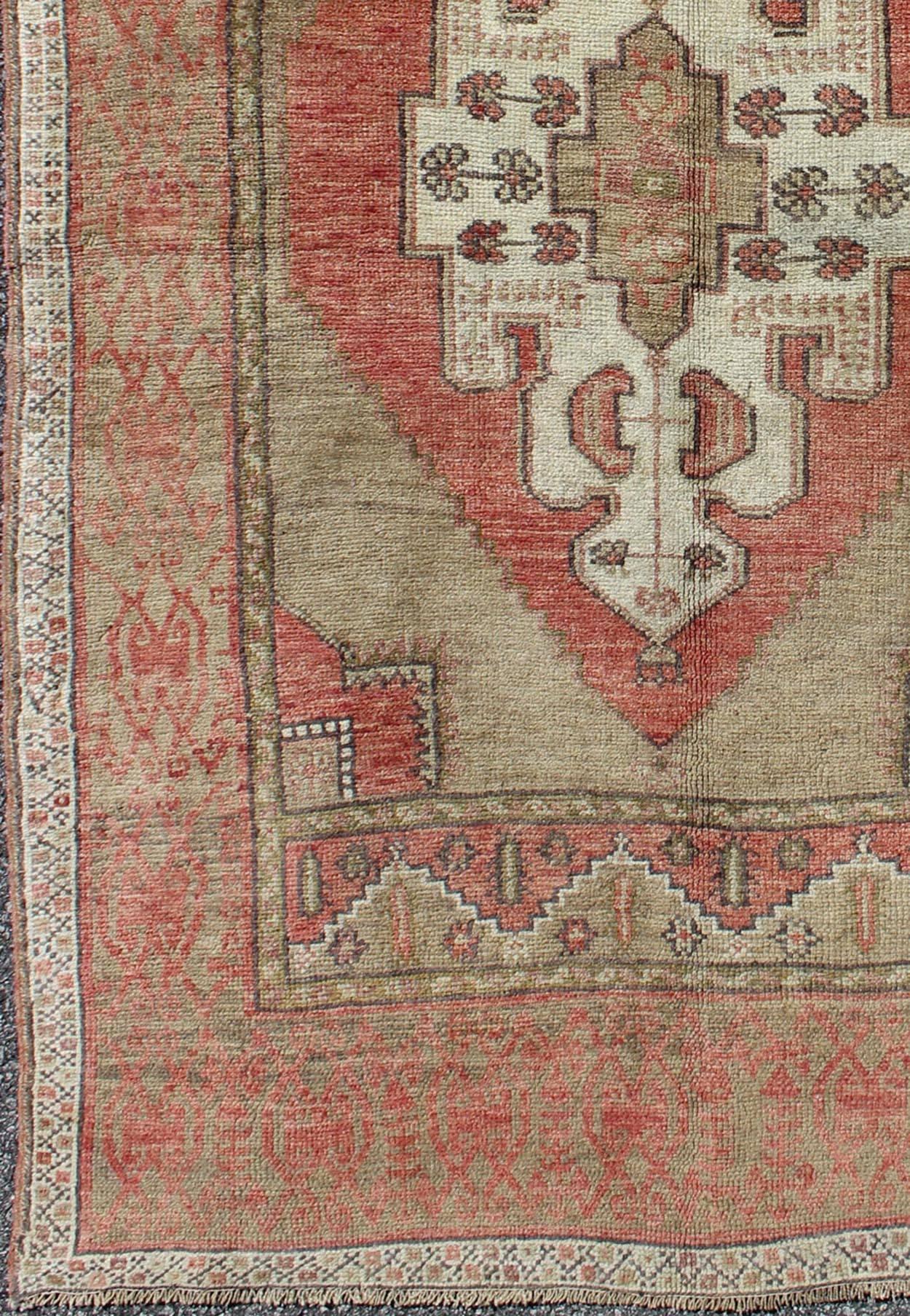 Olive green and red Oushak vintage Turkish rug with tribal medallion design, rug en-141924, country of origin / type: Turkey / Oushak, circa 1940

This vintage Turkish Oushak rug features an intricately beautiful design with a tribal aesthetic.