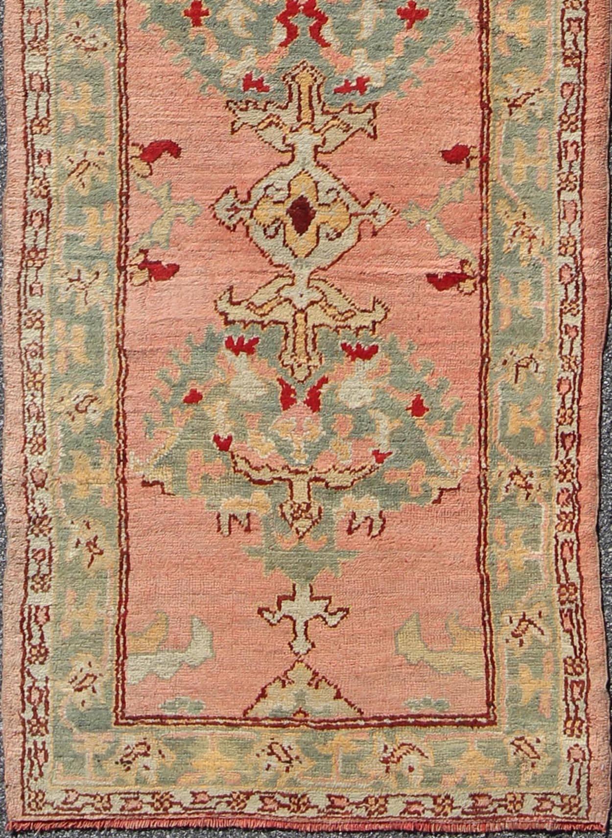 Salmon pink antique Turkish Oushak runner with stylized floral medallion design, rug h8-0402, country of origin / type: Turkey / Oushak, circa 1920

This vintage Turkish Oushak gallery runner (circa 1920) features a unique blend of colors and an