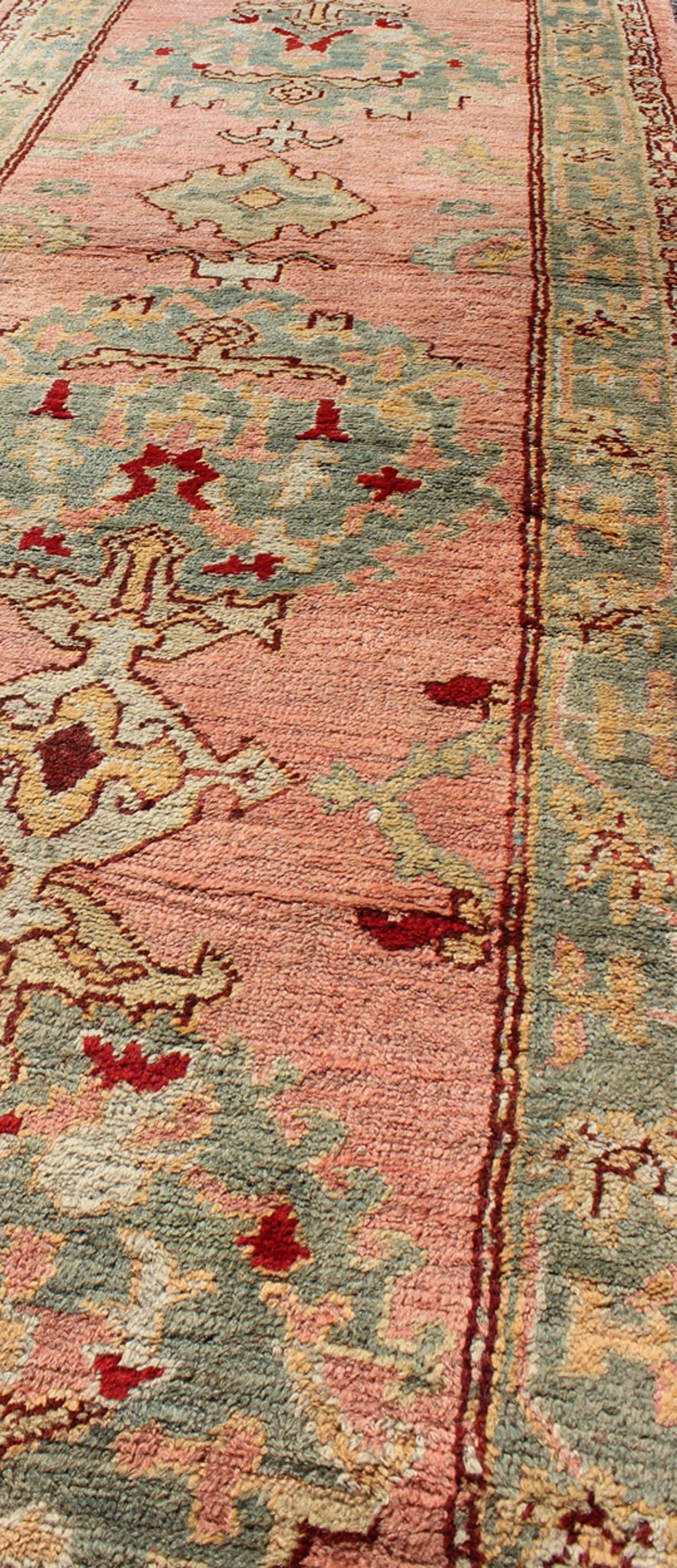 Early 20th Century Salmon Pink Antique Turkish Oushak Runner with Stylized Floral Medallion Design For Sale