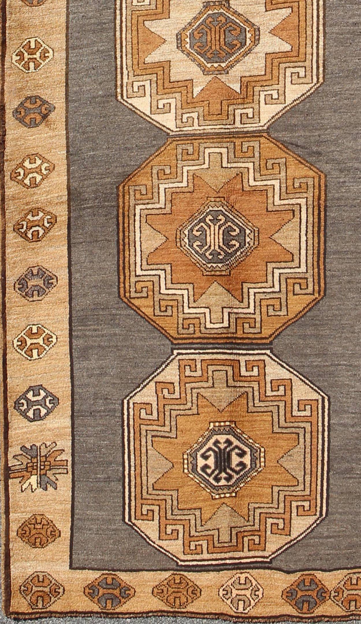 Shades of brown vintage Turkish Oushak runner with vertical medallion design, rug tu-TRS-136085, country of origin / type: Turkey / Oushak, circa 1940

This vintage Turkish Oushak gallery rug, (circa mid-20th century) features a unique blend of