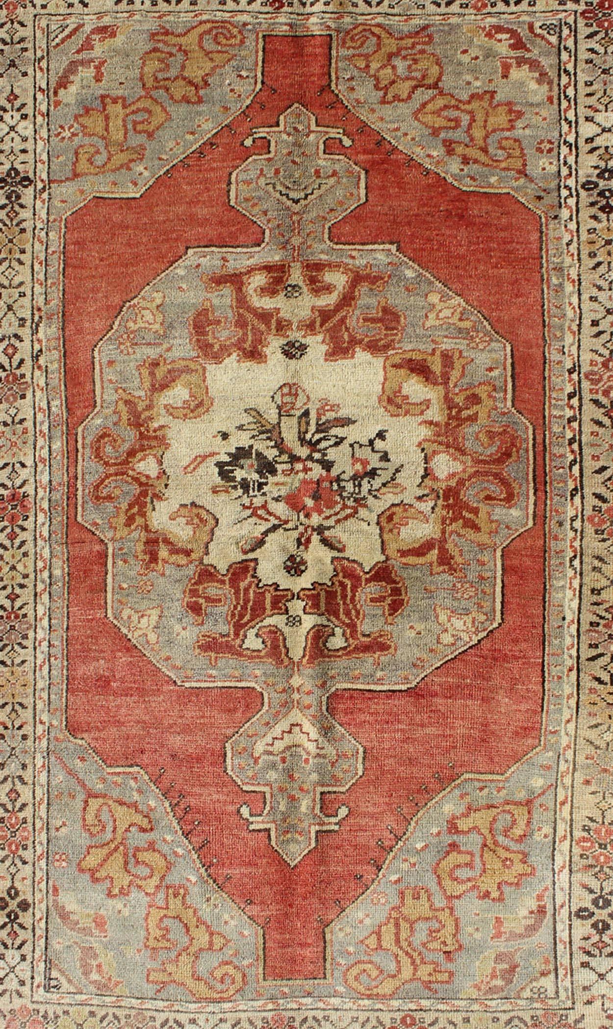 Hand-Knotted Faded Red and Taupe Vintage Turkish Oushak Rug with Layered Medallion Design For Sale